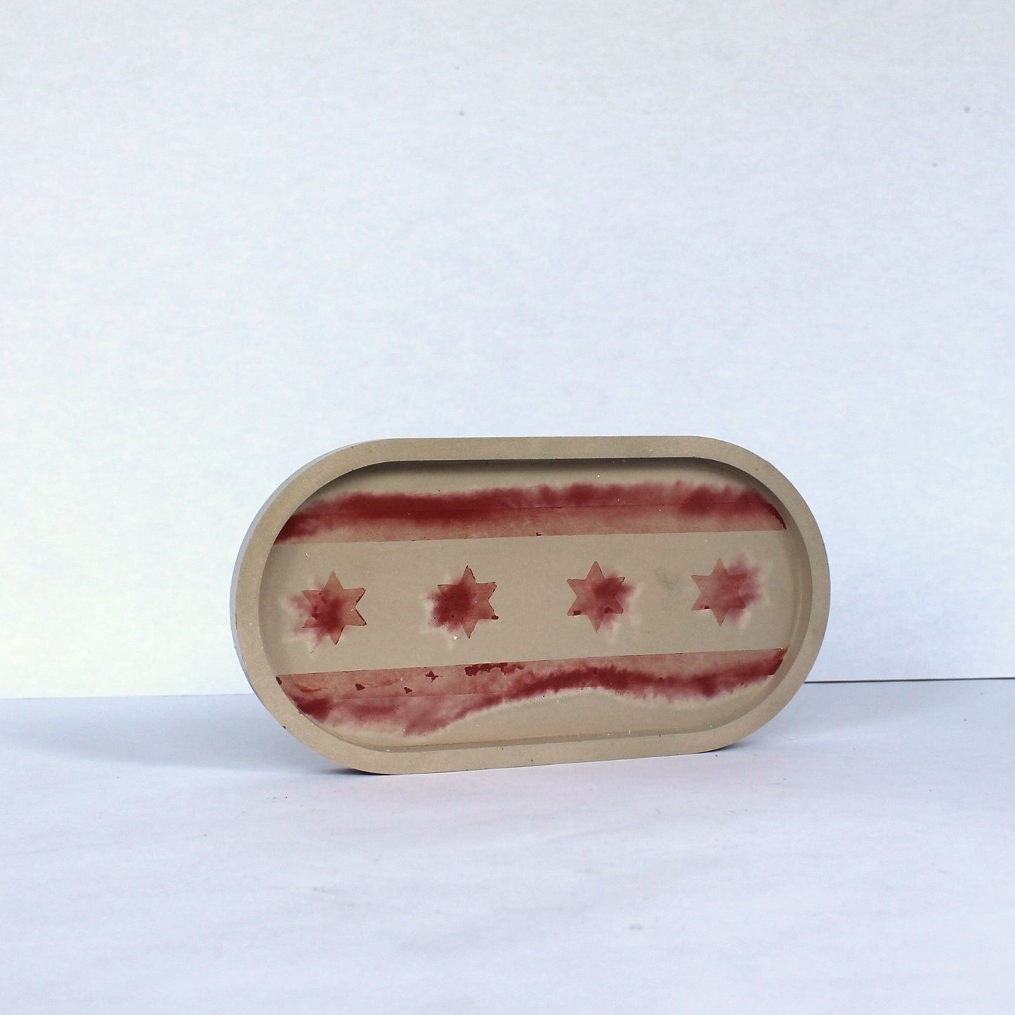 Oval concrete tray with red Chicago flag pattern on a white background
