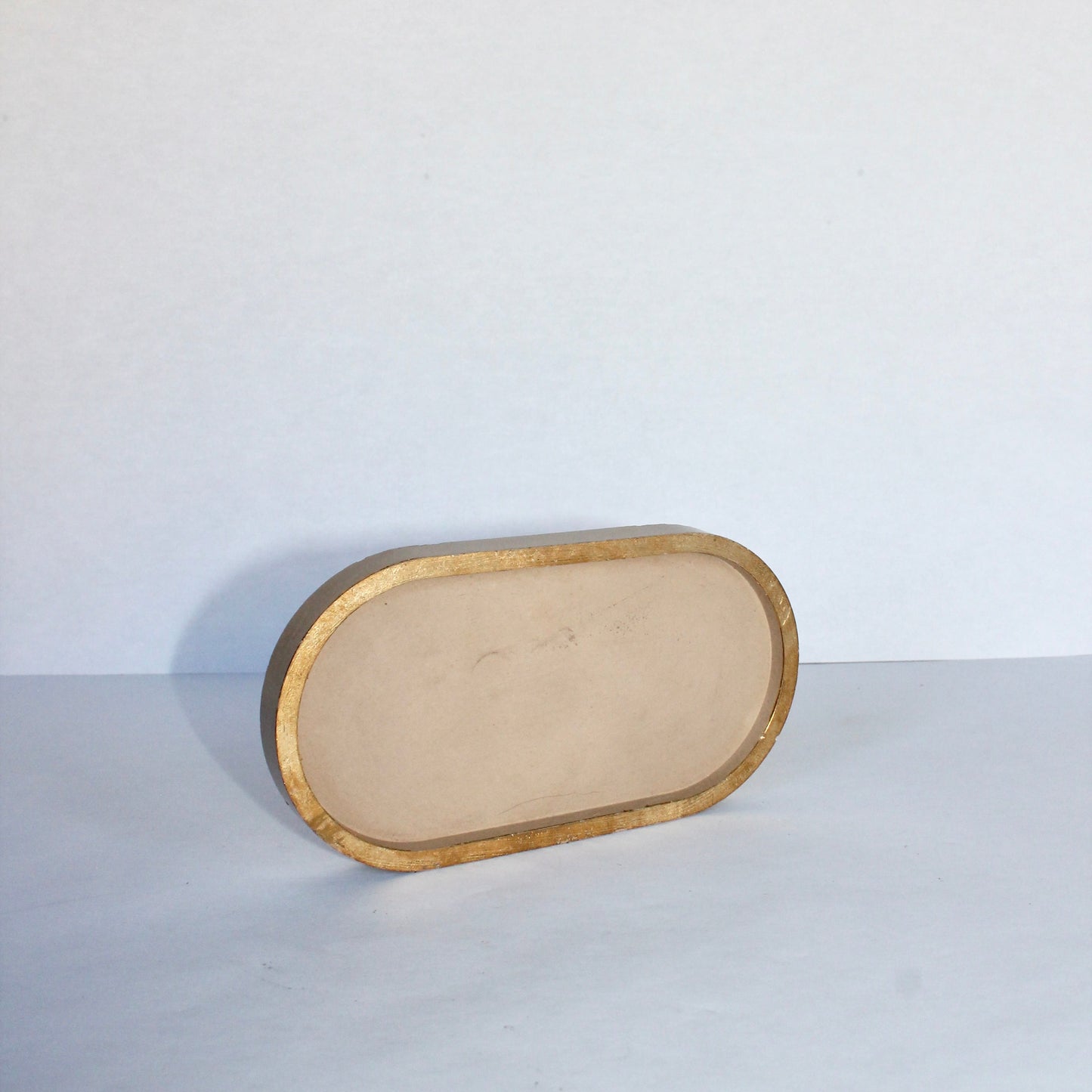 Rectangular beige concrete tray with gold edge on a white background