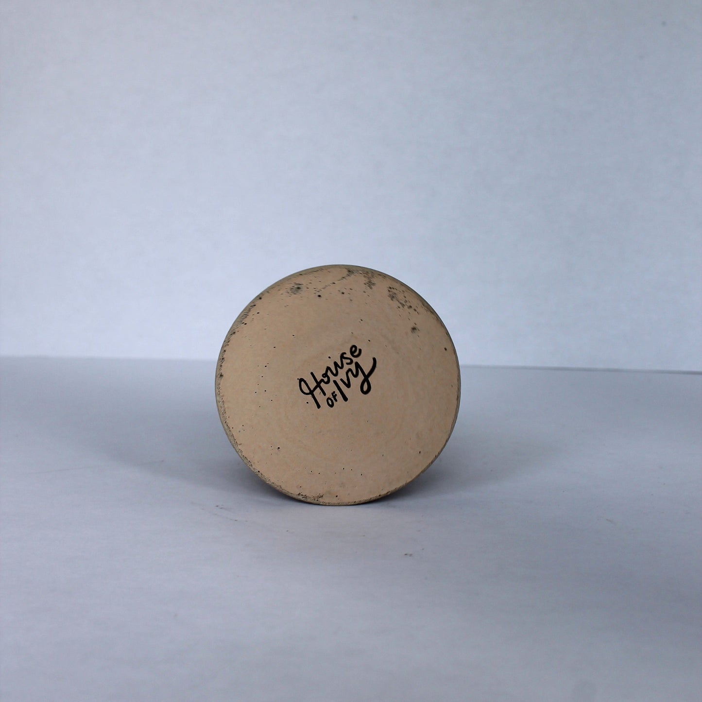 Bottom of round concrete dish with 'House of Ivy' branding on a white background