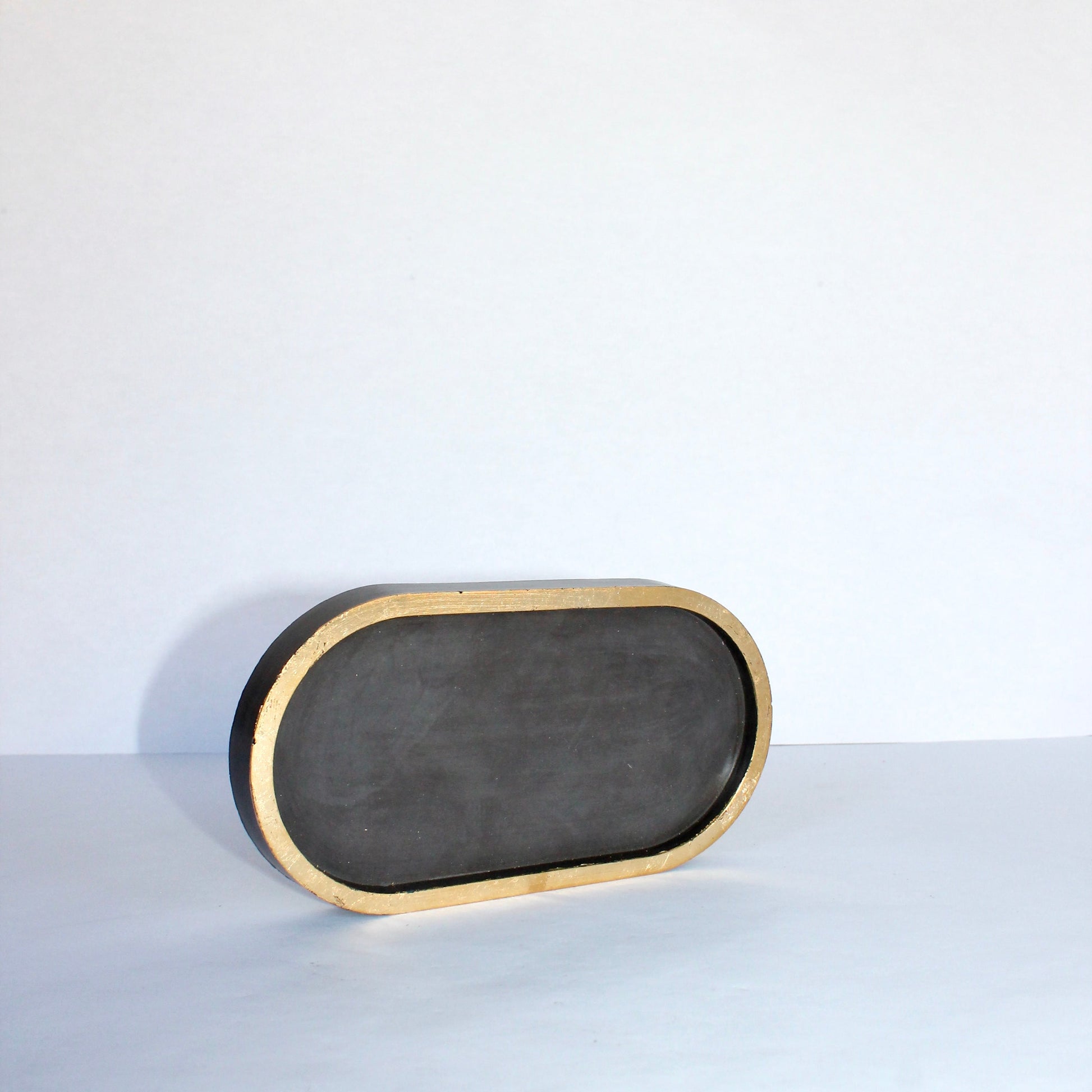 Rectangular black tray with gold rim on a white background