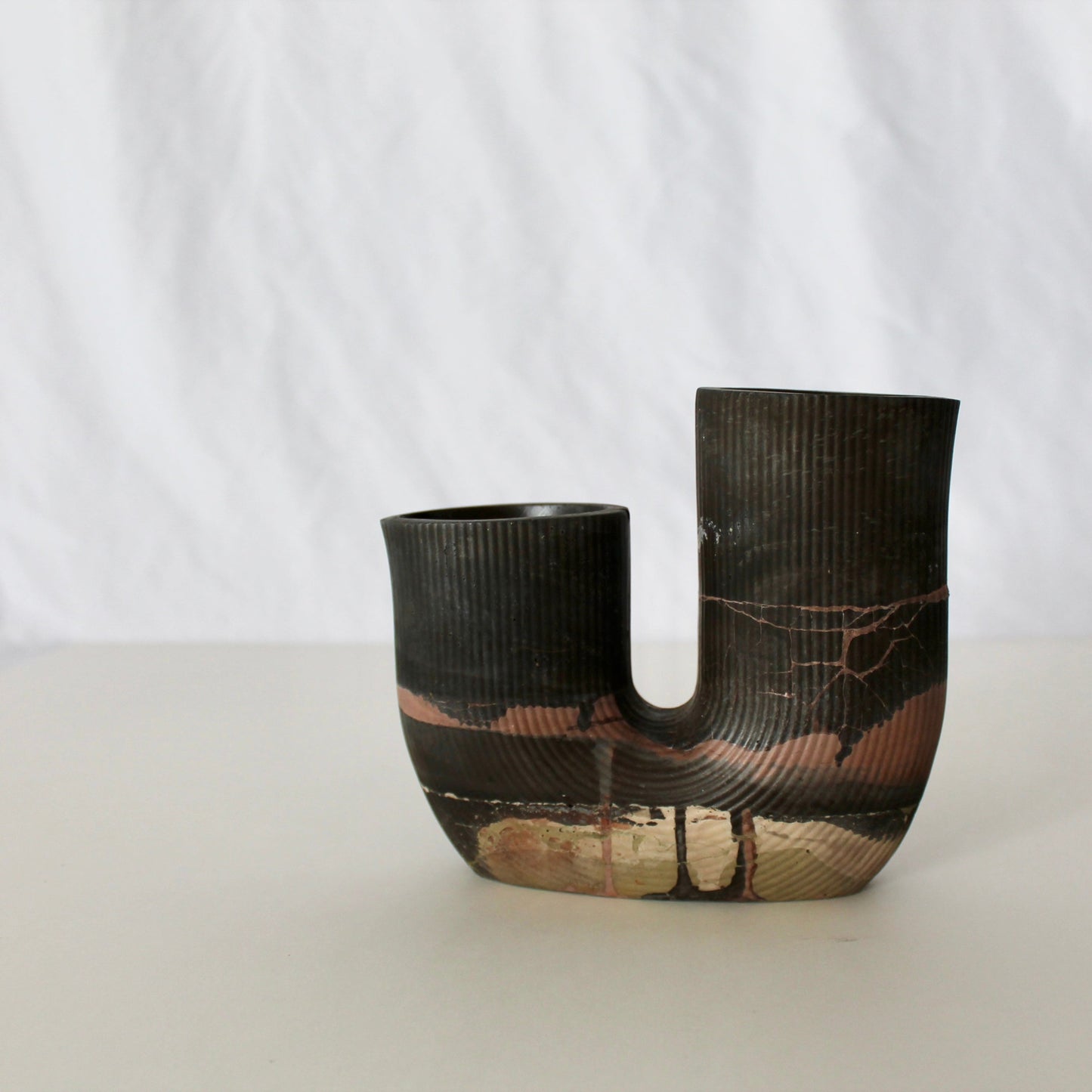 Black concrete vase with textured design on a white background