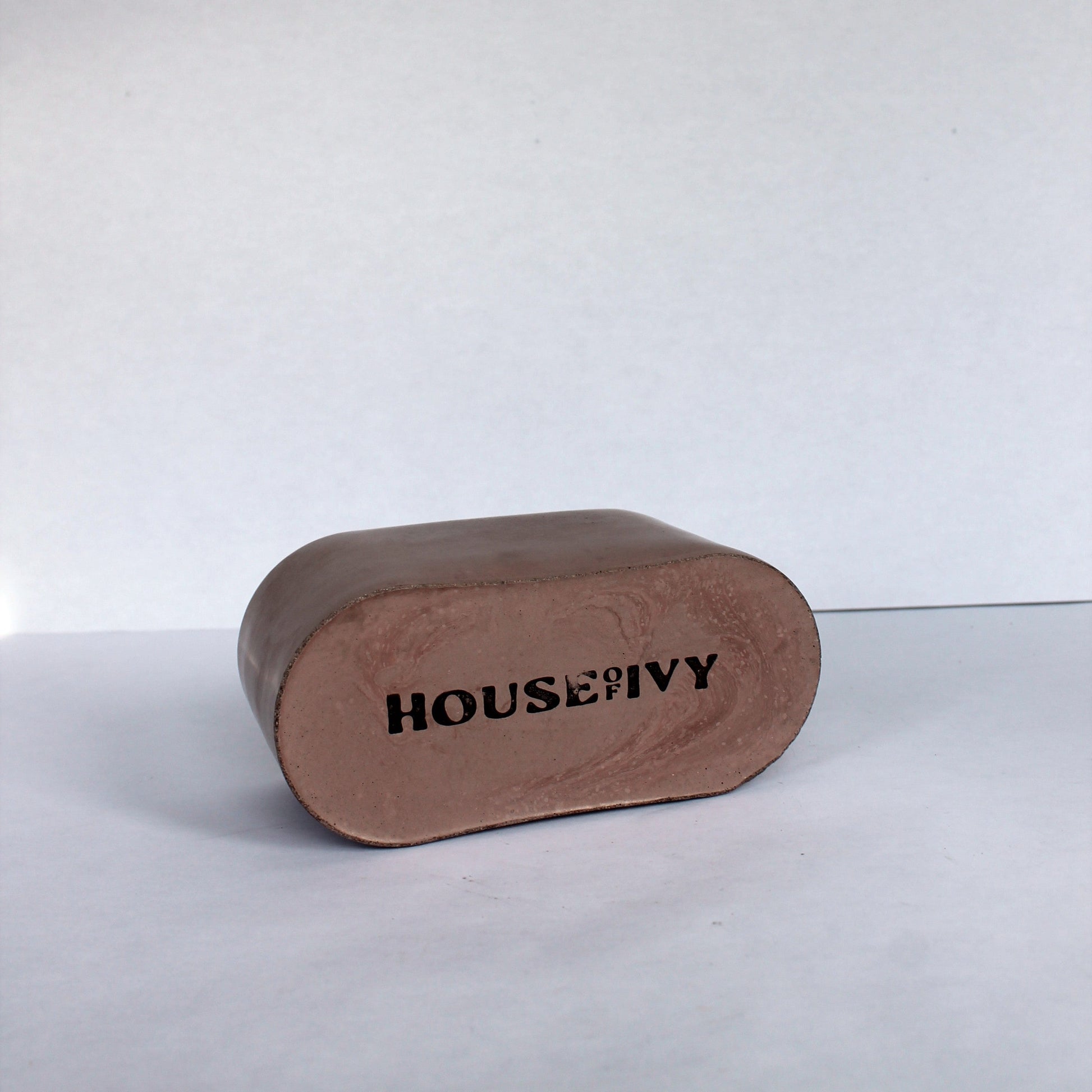 bottom of brown concrete dish with 'HOUSE OF IVY' branding on a white background