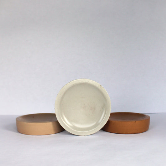Three neutral concrete bowls on a white background