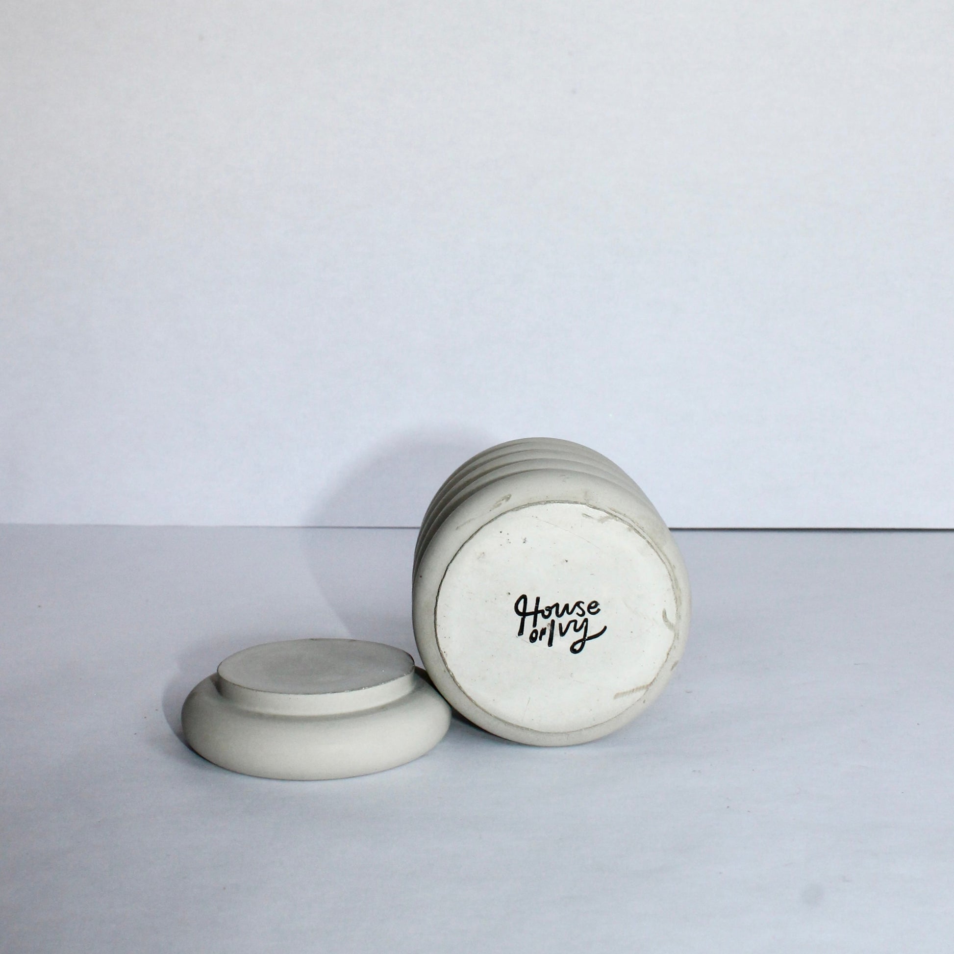 Gray concrete container with black text of House of Ivy branding on a white background
