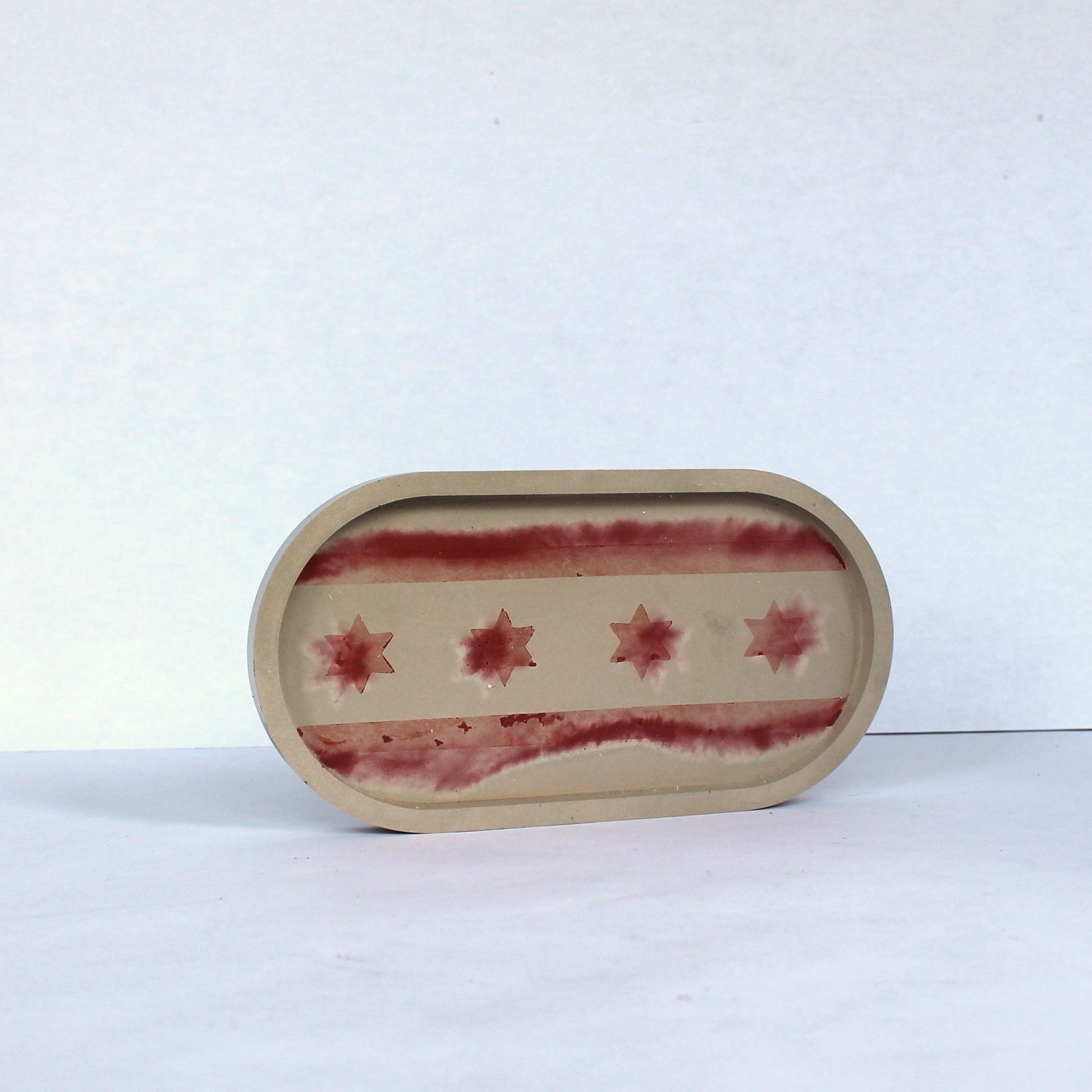Oval concrete tray with red Chicago flag pattern on a white background
