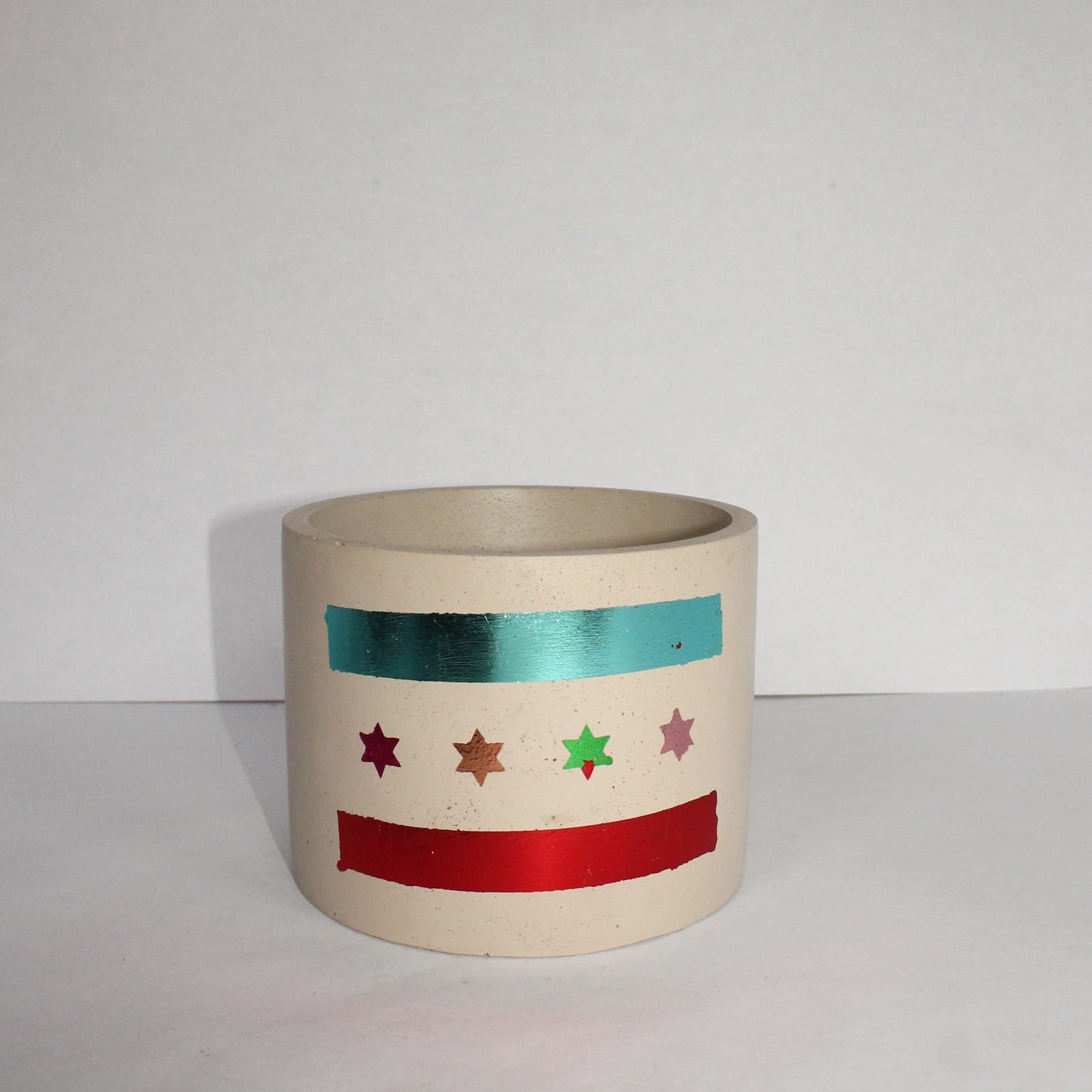 Concrete pot with decorative multi-color Chicago flag design on a white background
