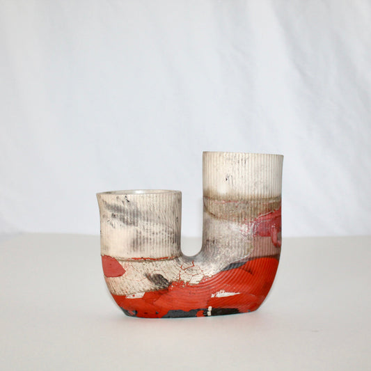 beige and orange cement vase with abstract design on a white background
