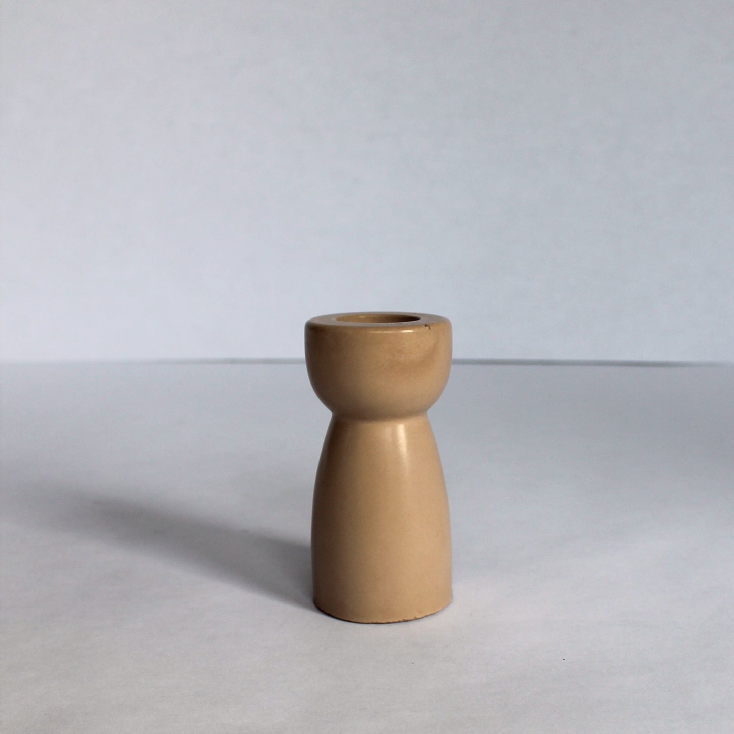 Beige concrete candle stick holder on a white background