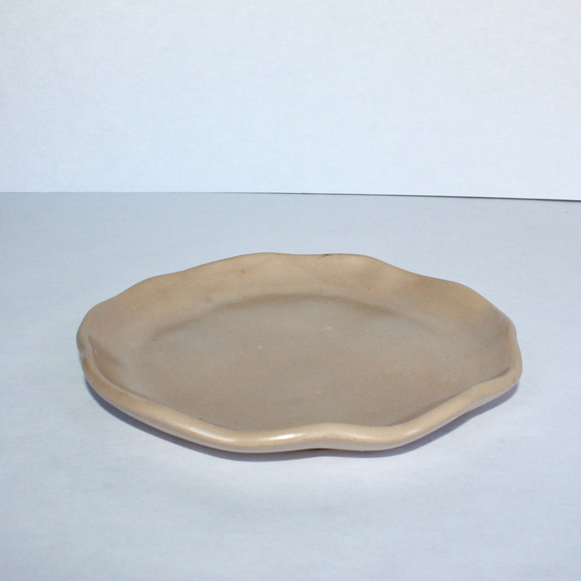 Beige ceramic plate on a white background