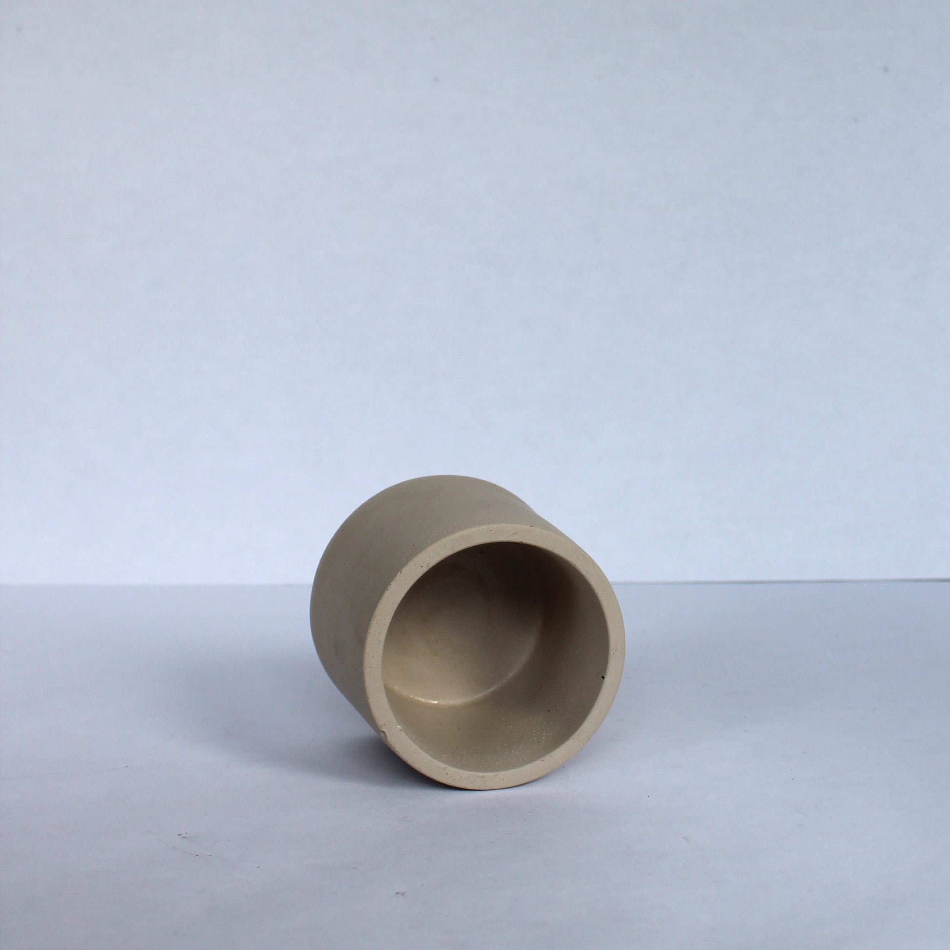 Beige concrete pot on a white background