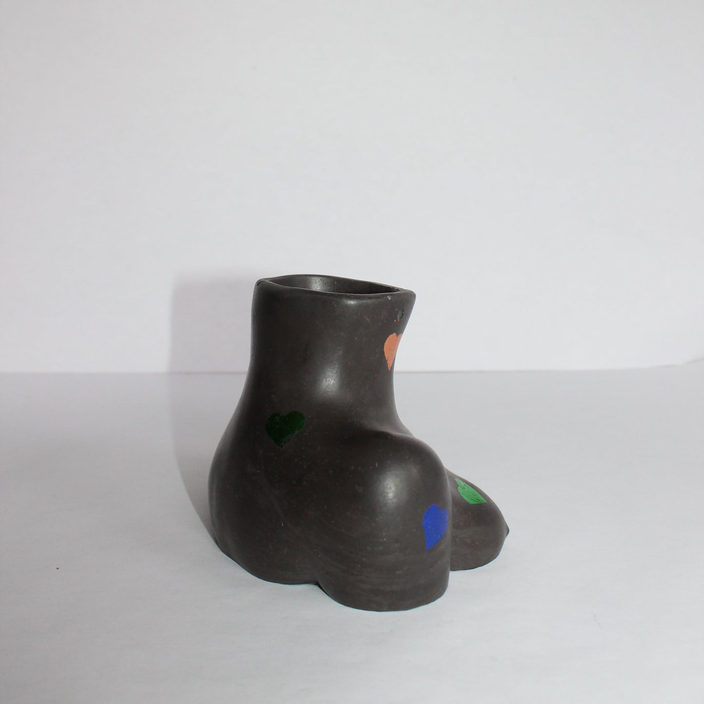 Black concrete female shaped vase on a white background