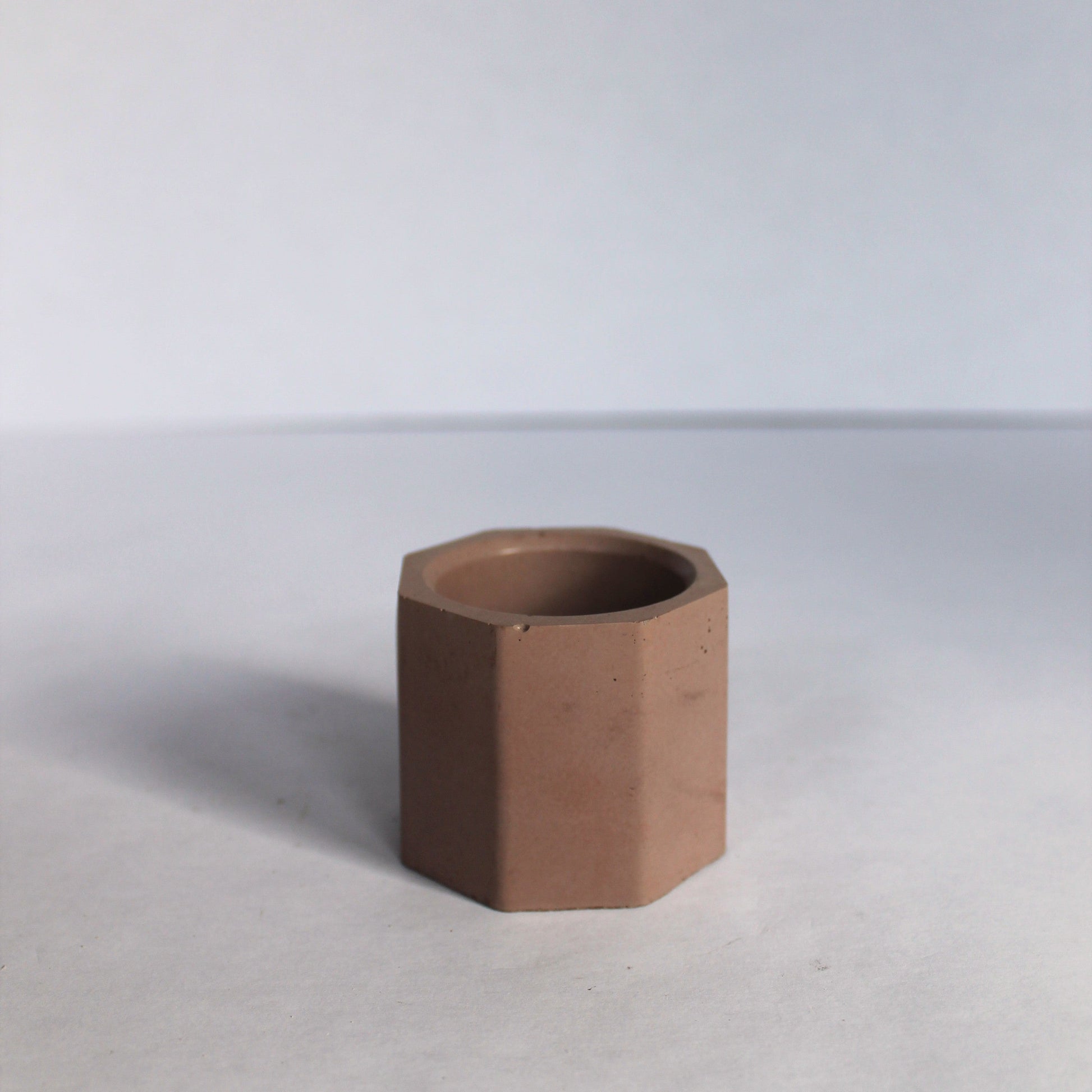 Hexagonal brown concrete planter on a white background