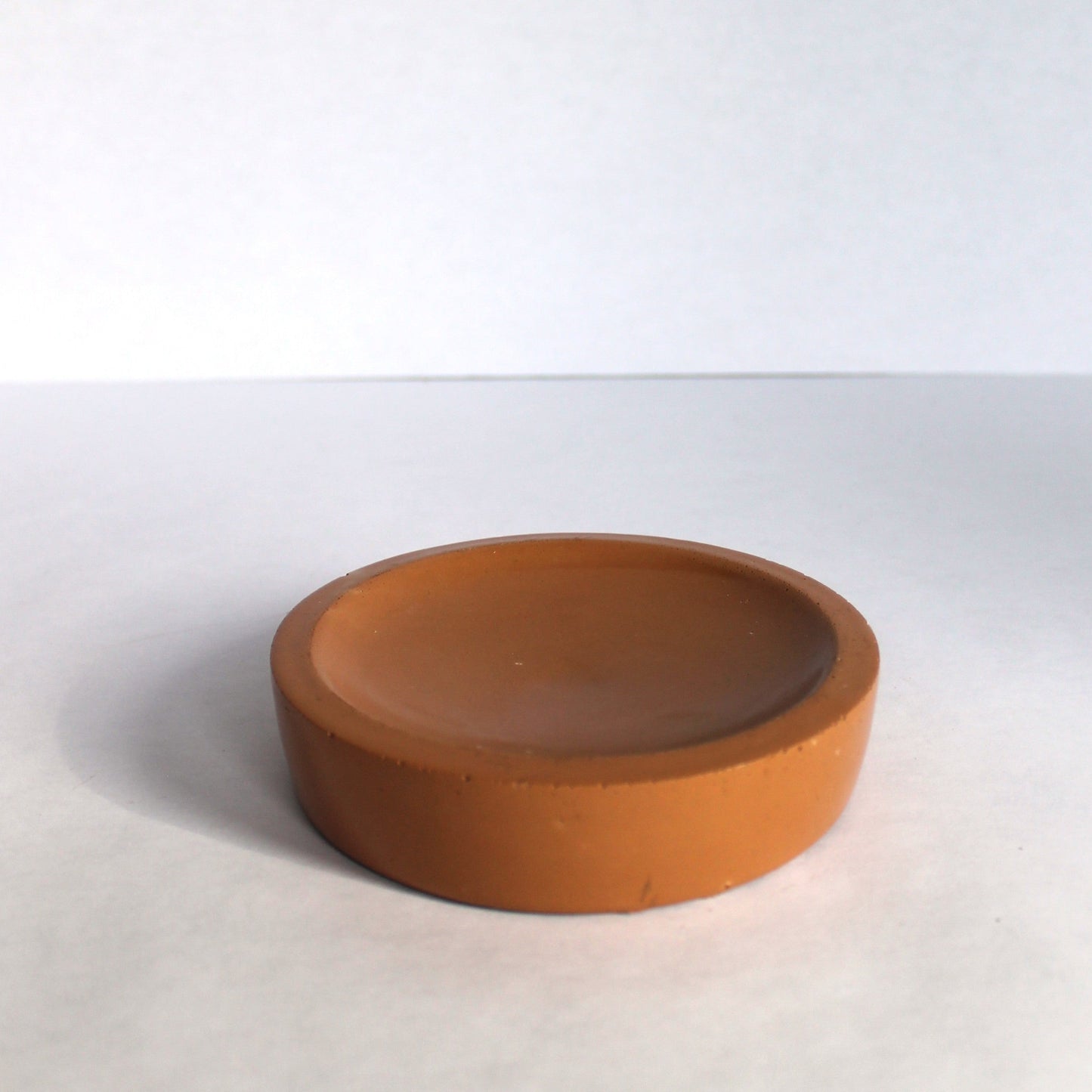 Round terracotta dish on a white background