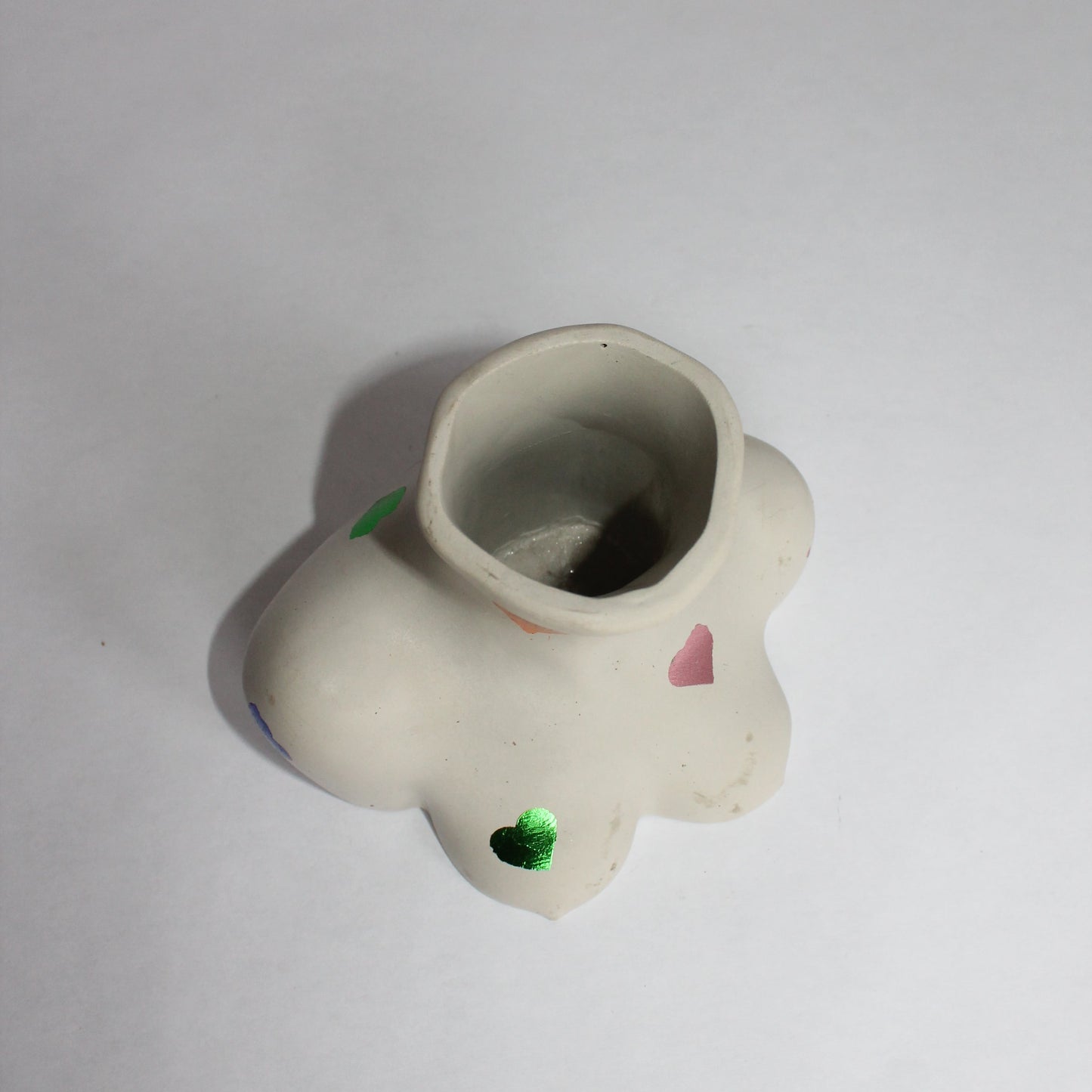 White concrete object with multi-colored hearts on a white background