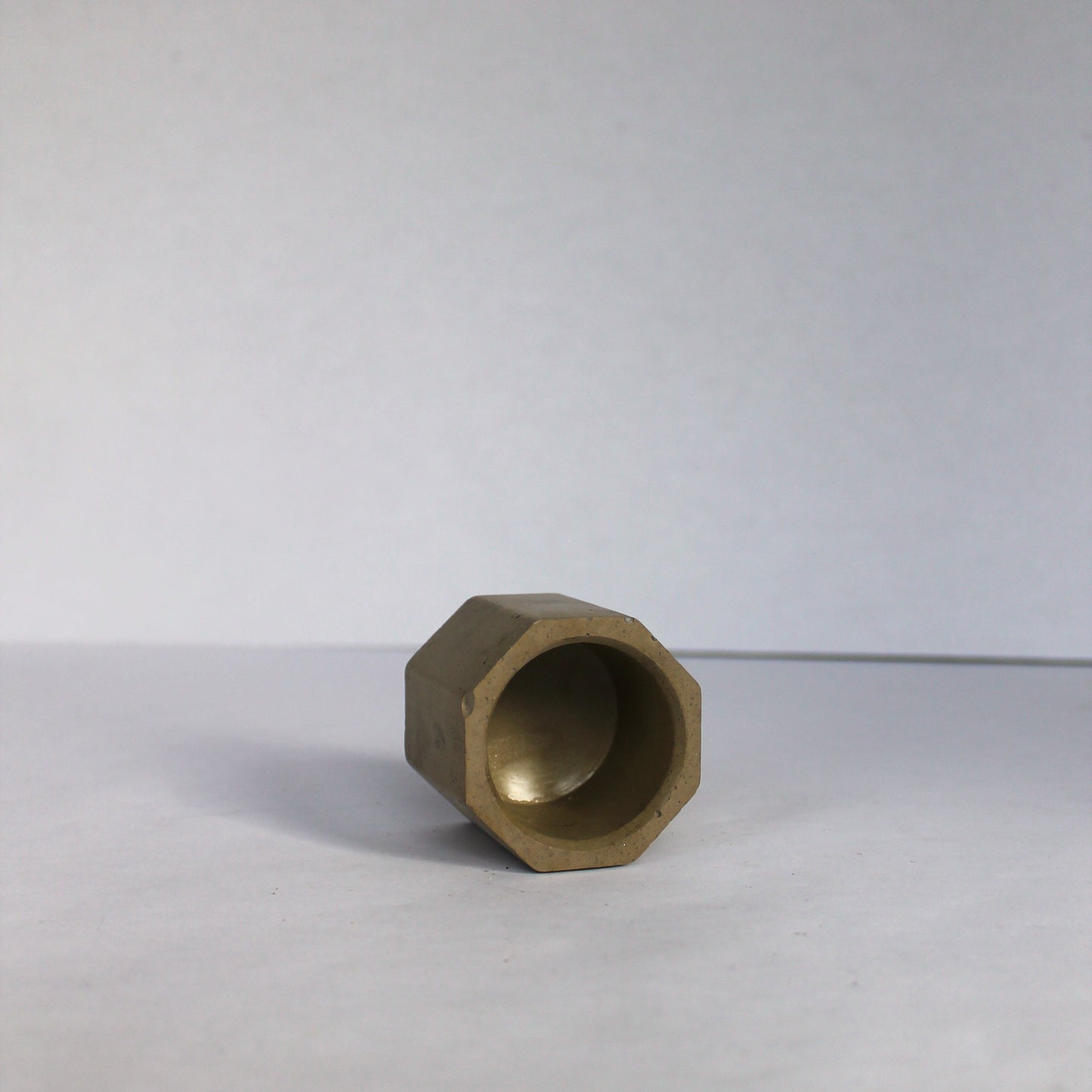 Inside view of a green hexagonal concrete tea light holder on a white background