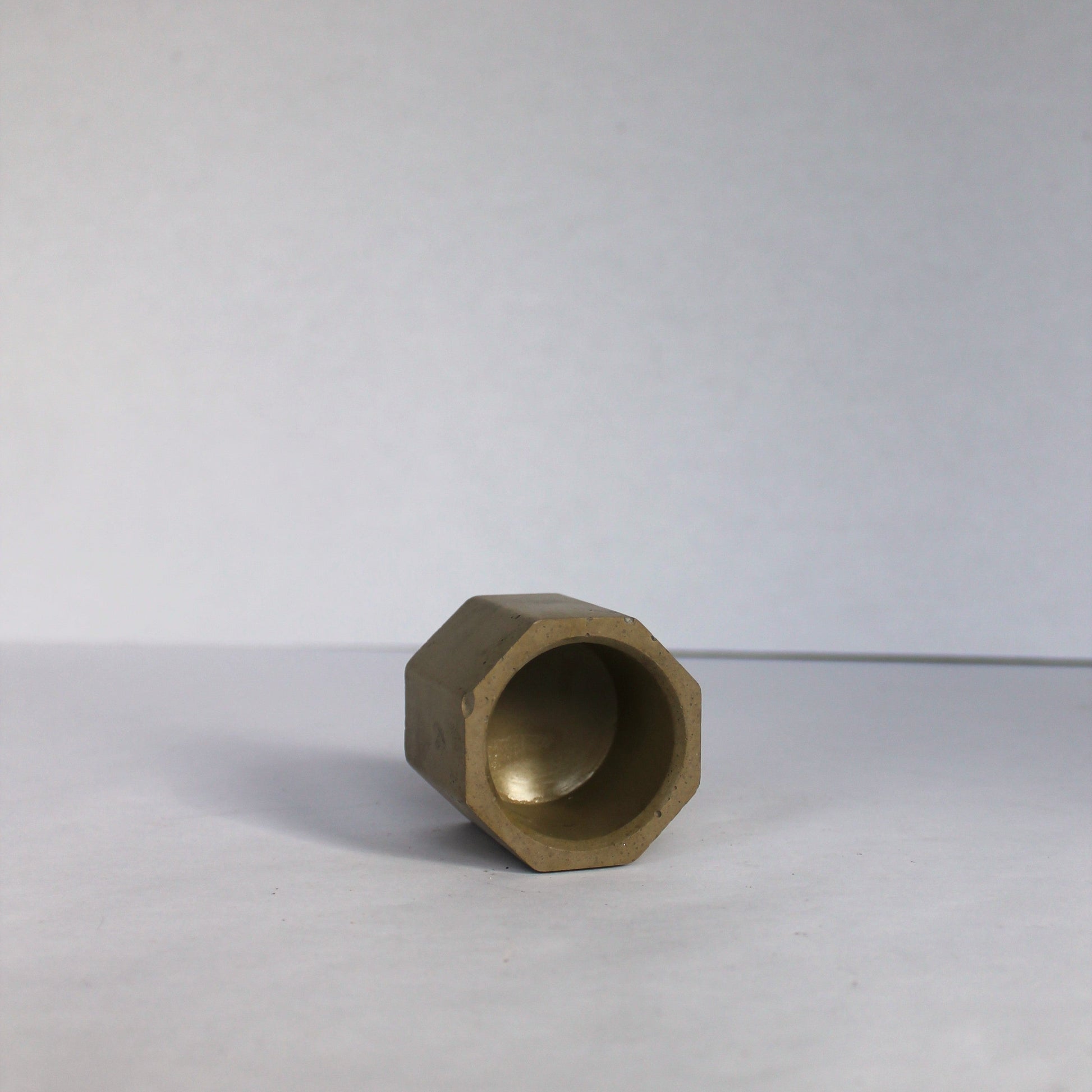 Inside view of a green hexagonal concrete tea light holder on a white background