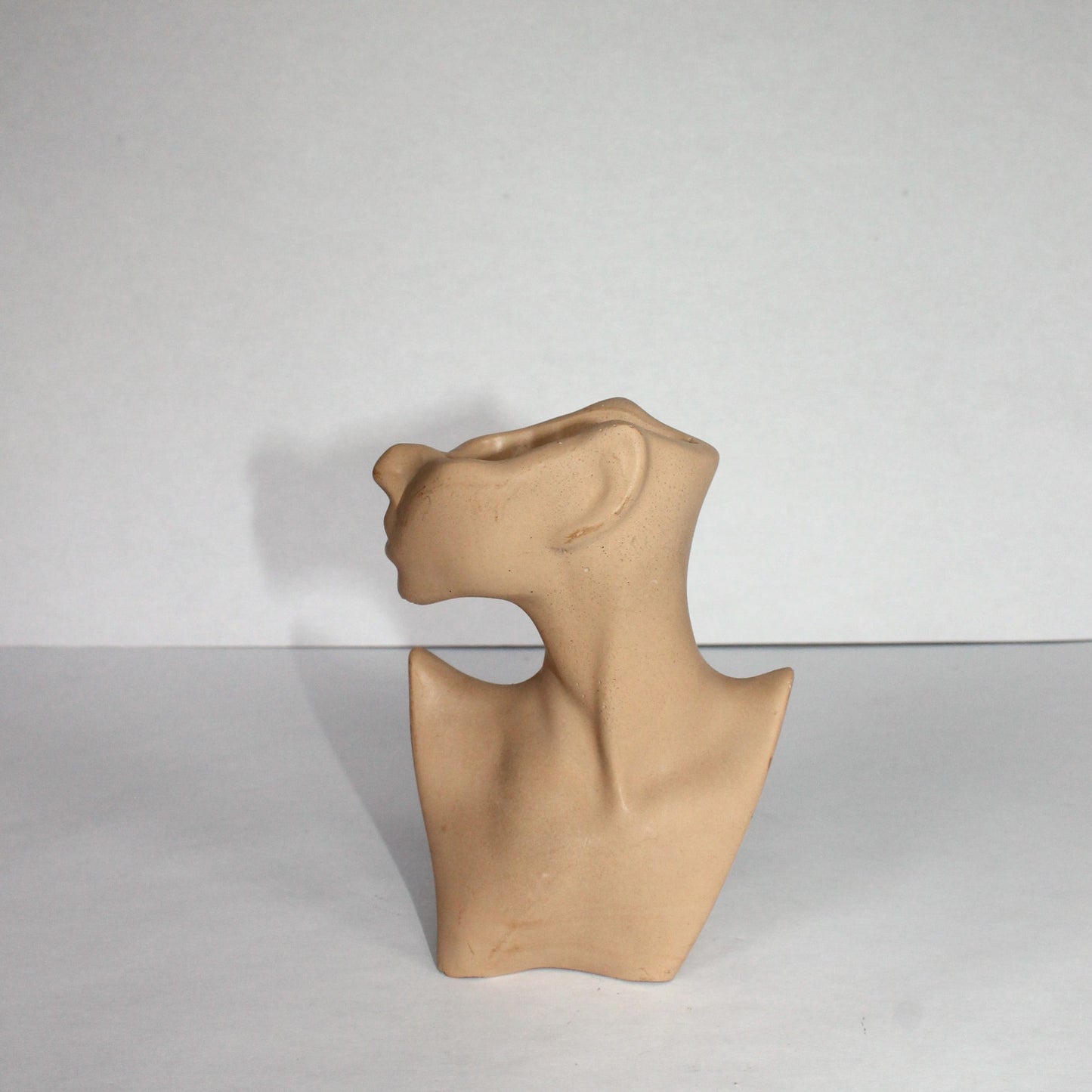 Beige abstract body sculpture on a white background