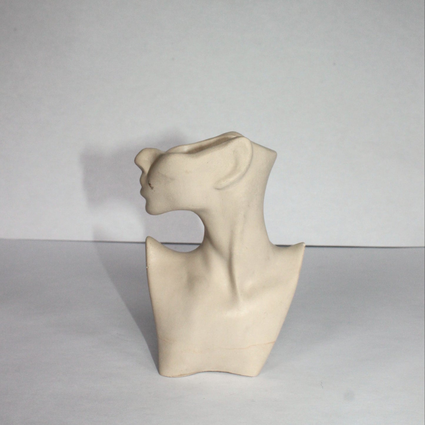 light gray sculpture of a abstract figure on a white background