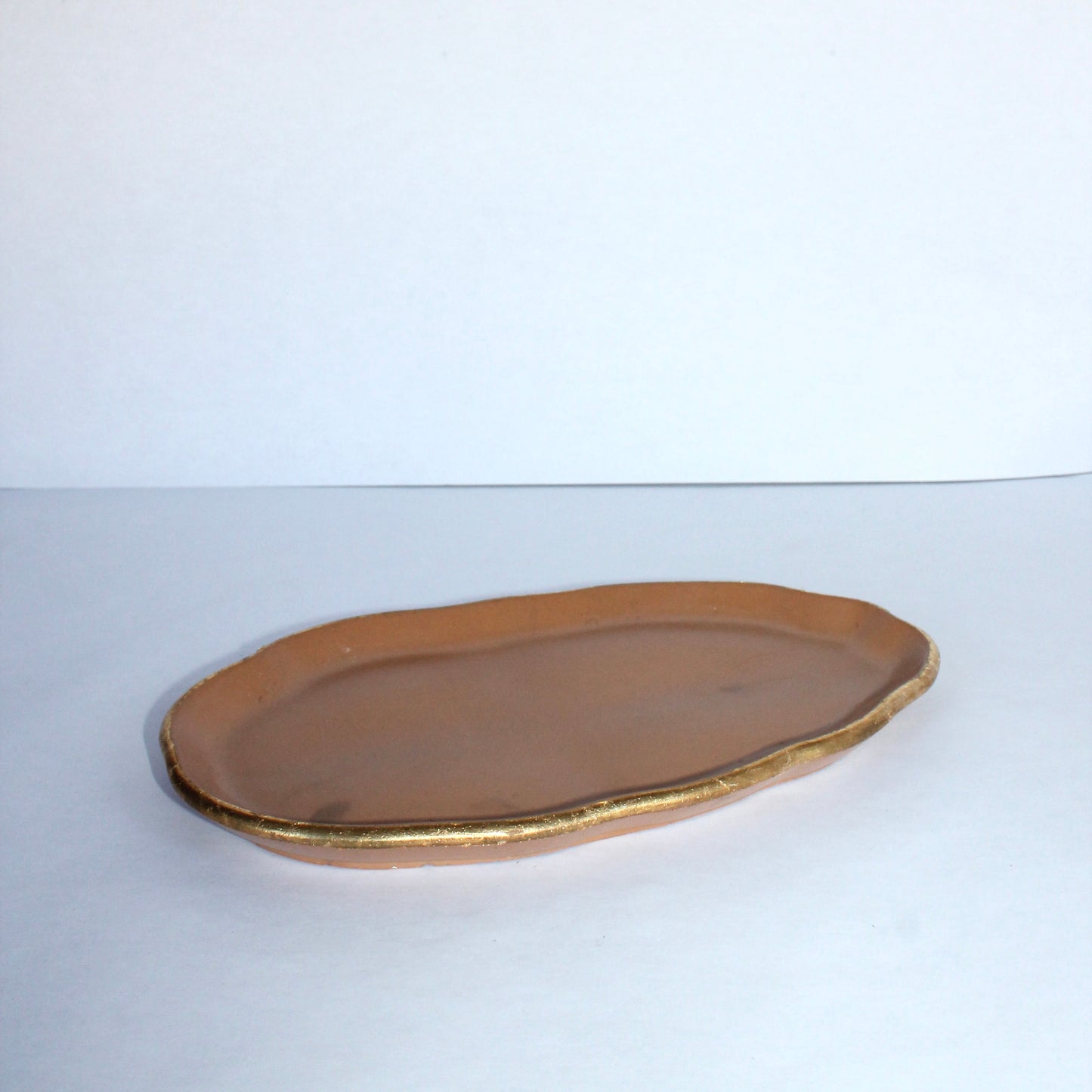 terracotta colored concrete platter on a white background