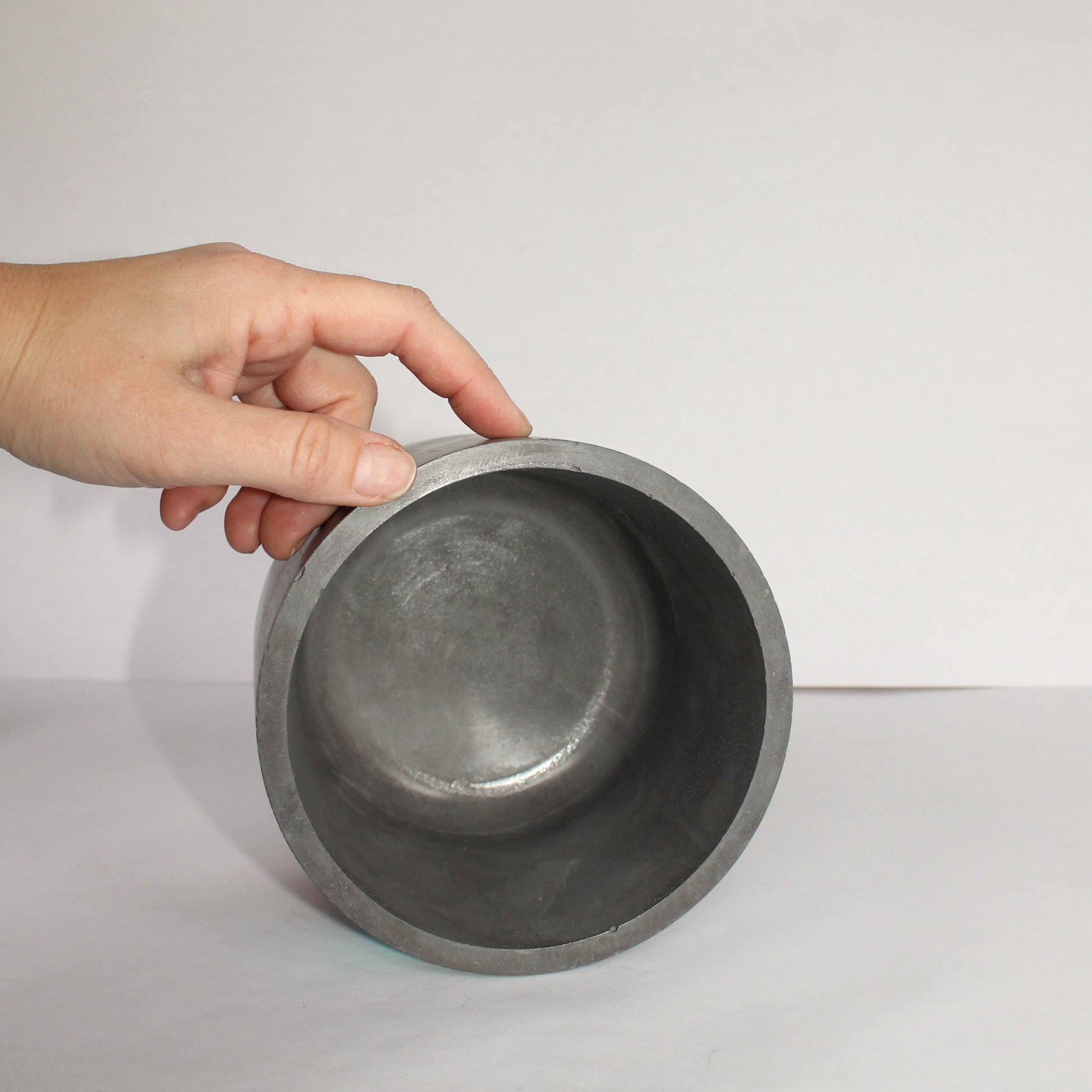 Hand holding a metallic Chicago flag design planter against a plain background