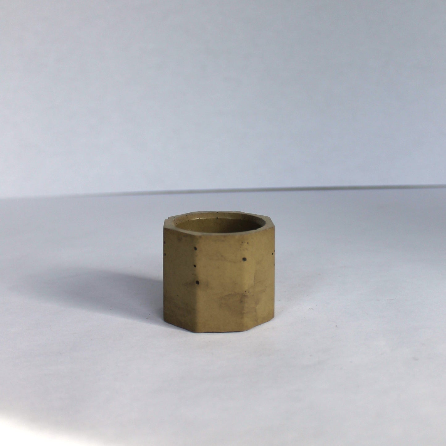 Green hexagonal concrete vessel on a white background