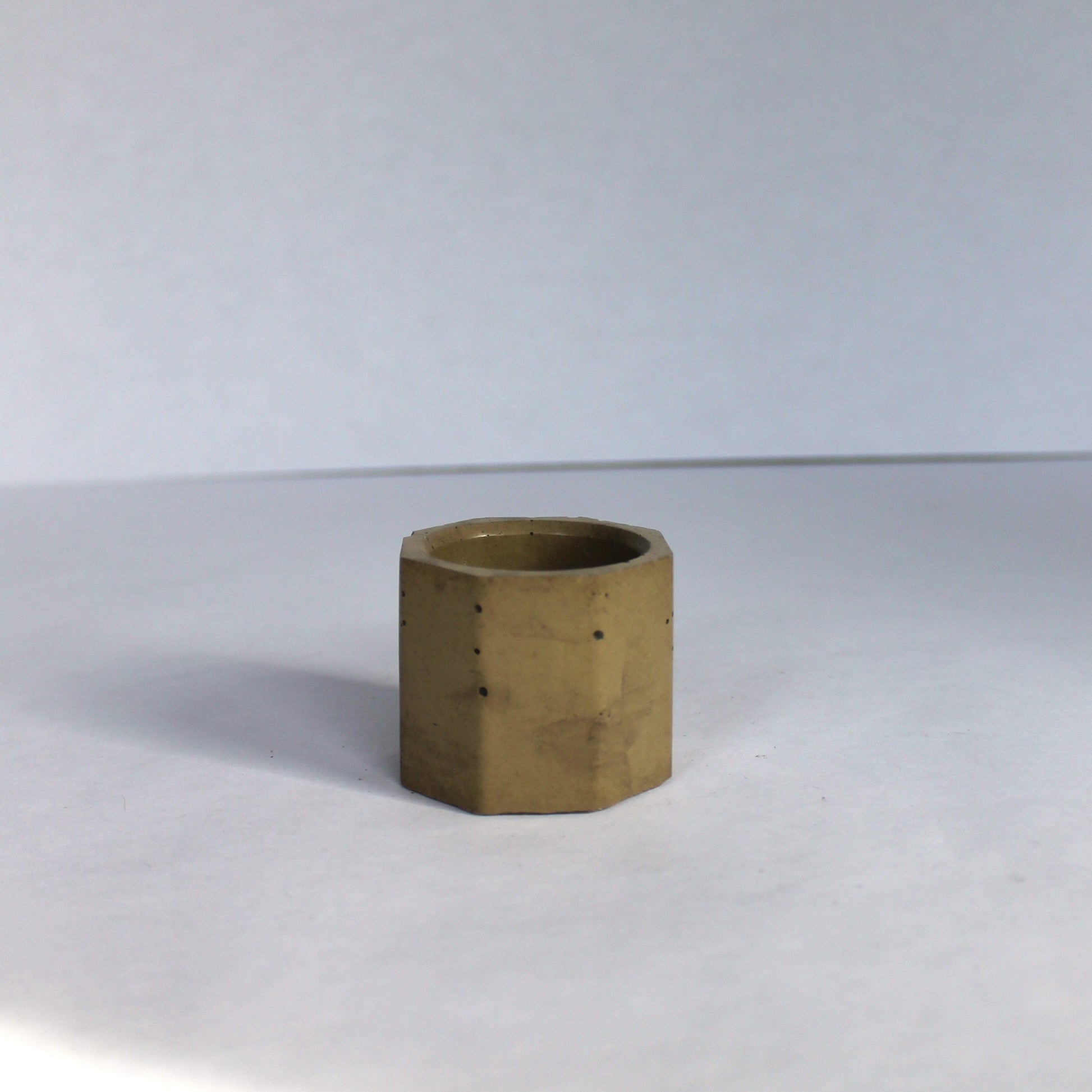 Green hexagonal concrete vessel on a white background