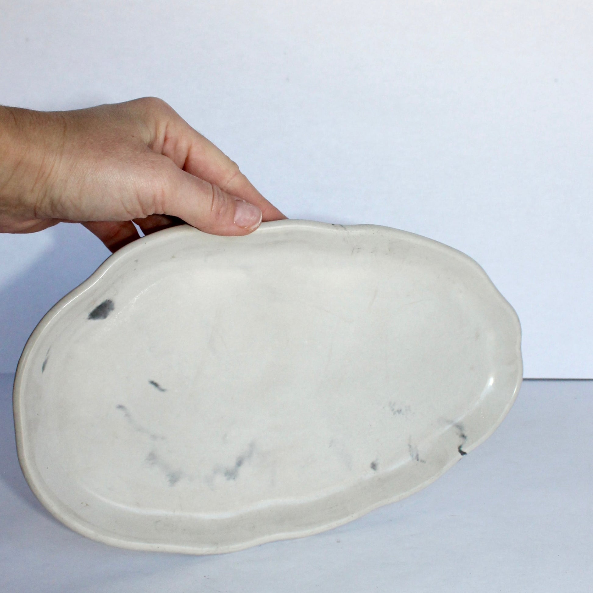 Hand holding a concrete plate with a white background