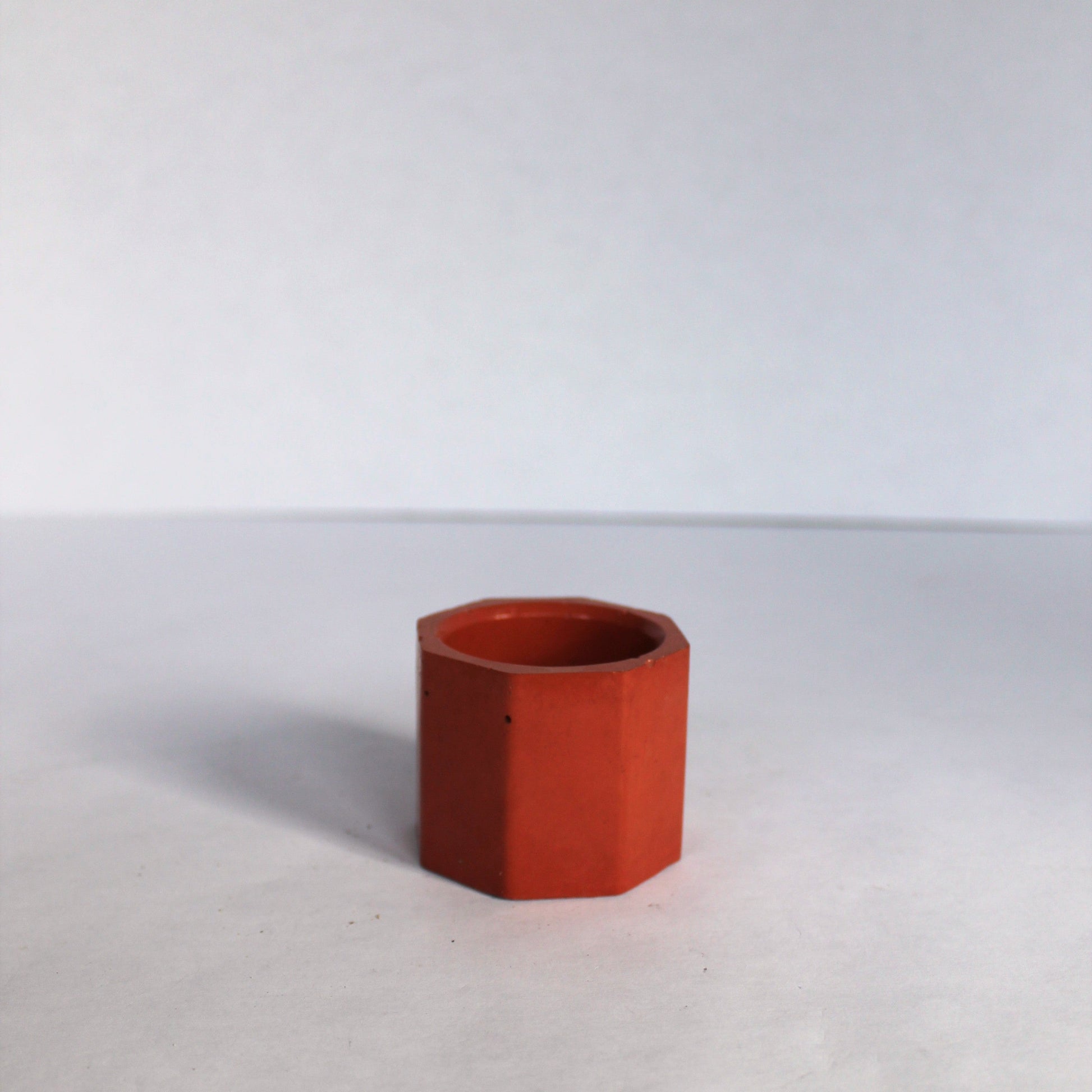 orange concrete dish on a white surface with a white background