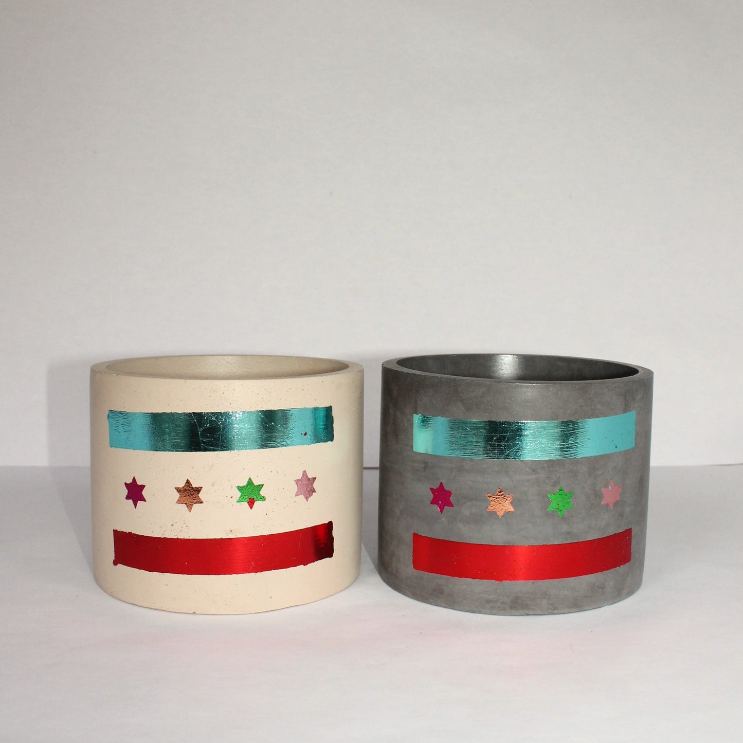 Two decorative concrete pots with Chicago flag star and stripe patterns on a white background