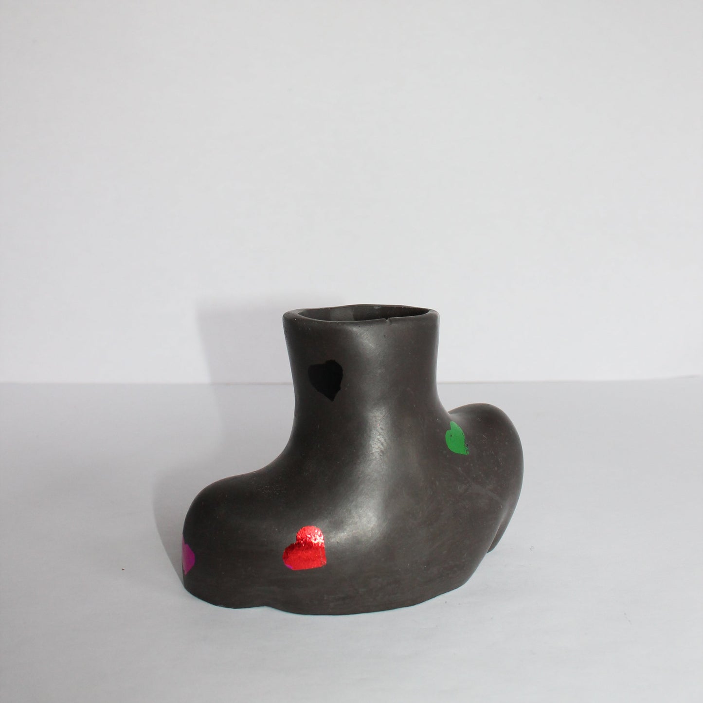 Black Vivian Vase with colored hearts on a white background