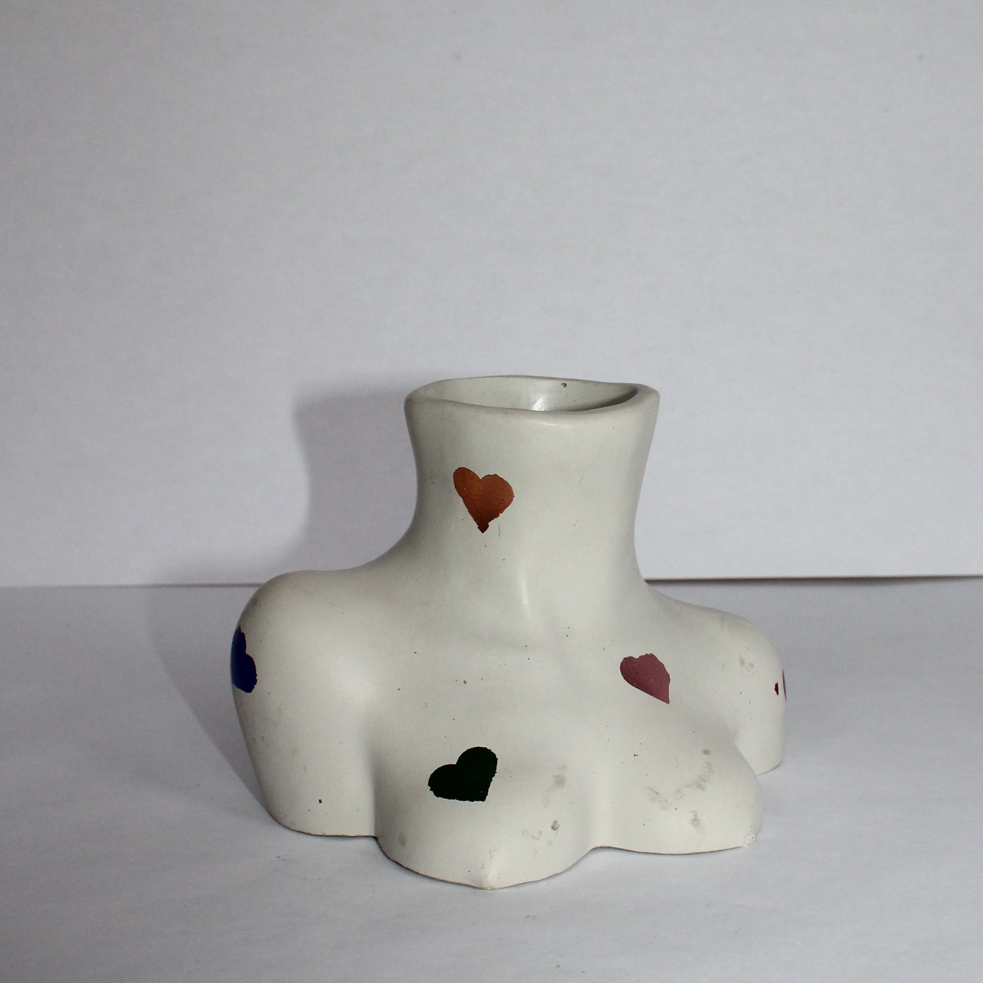 light gray concrete object with red and green and gold hearts on a white background