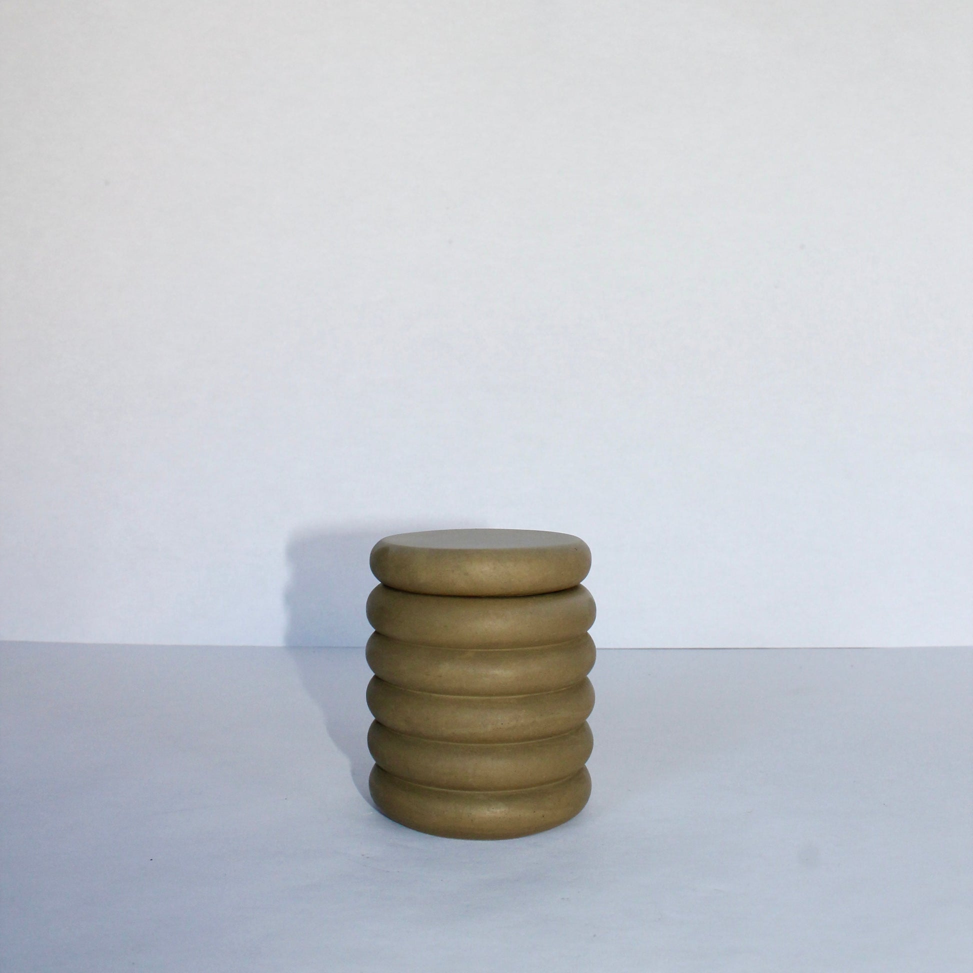 Green concrete jar with ribbed design on a white background