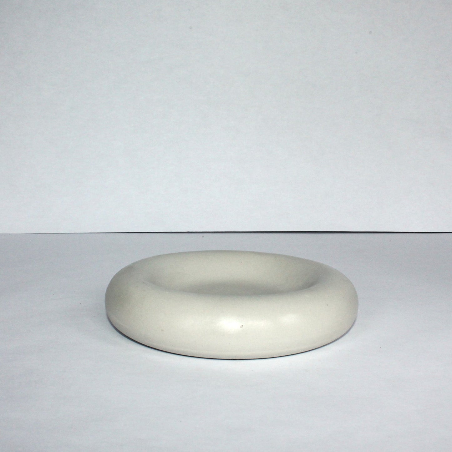 light gray round concrete tray on a white background
