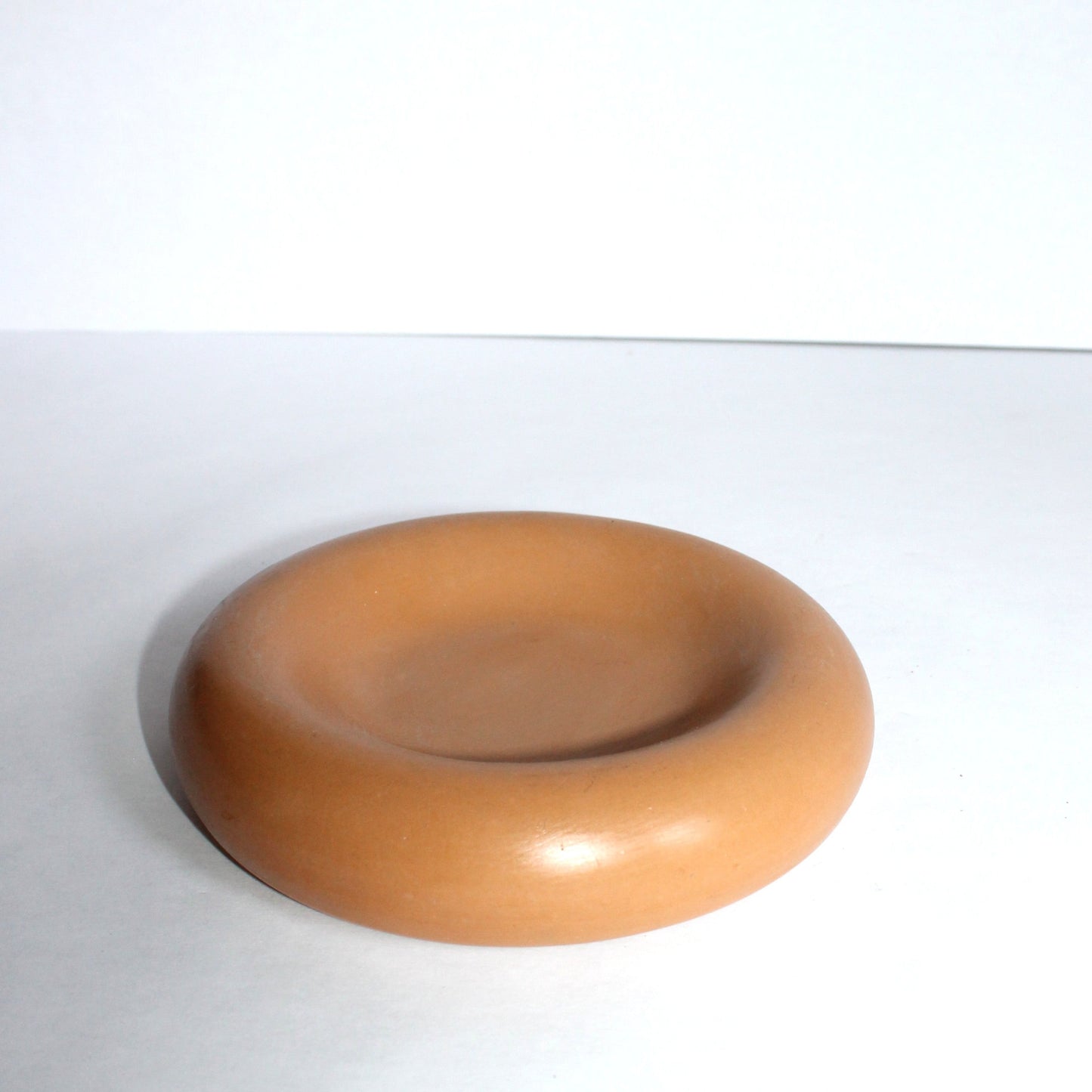 terracotta colored concrete round tray on a white background