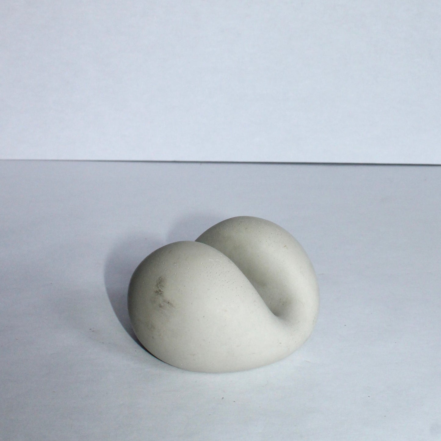 Sculptural chic phone stand resembling a stone or marble on a white background