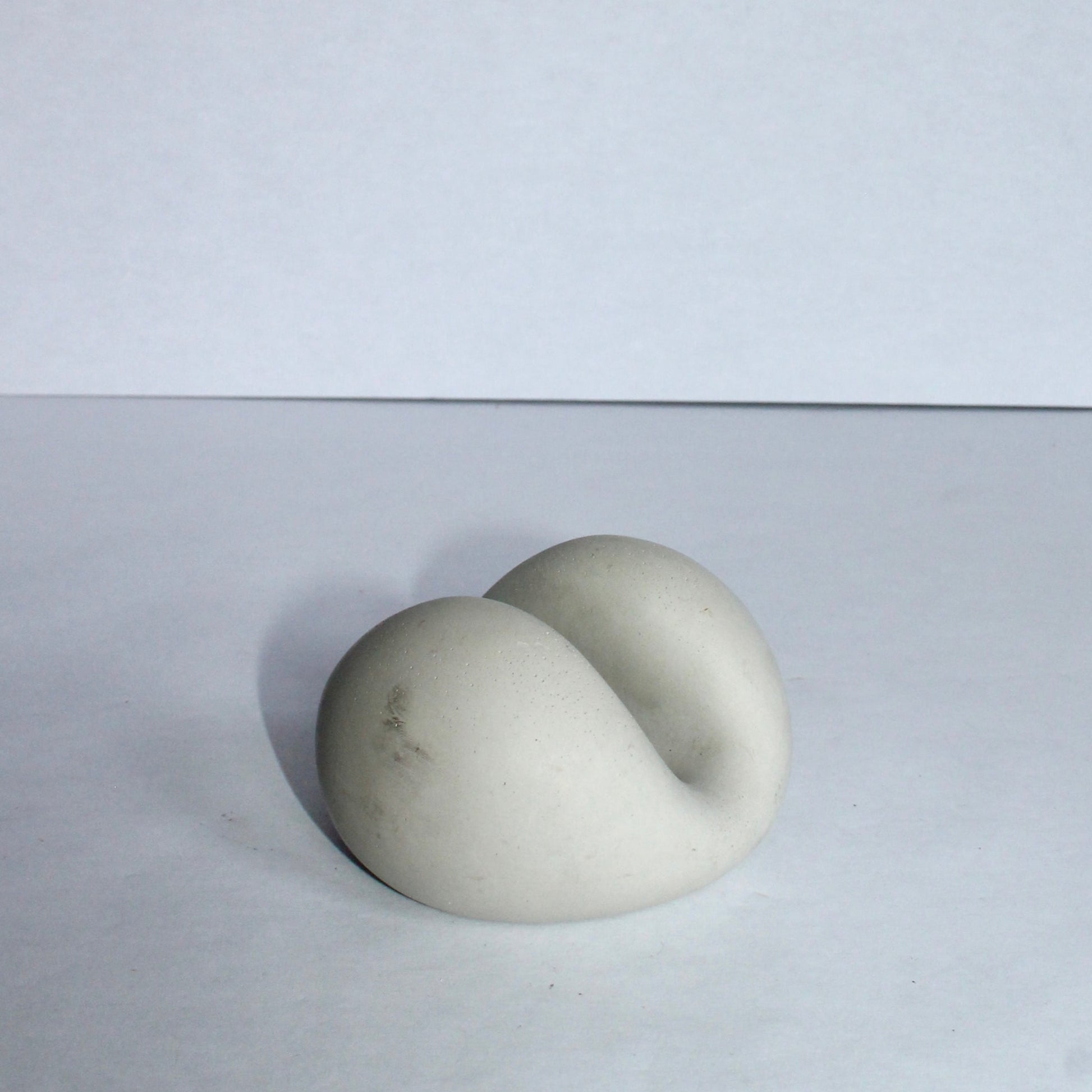 Sculptural chic phone stand resembling a stone or marble on a white background