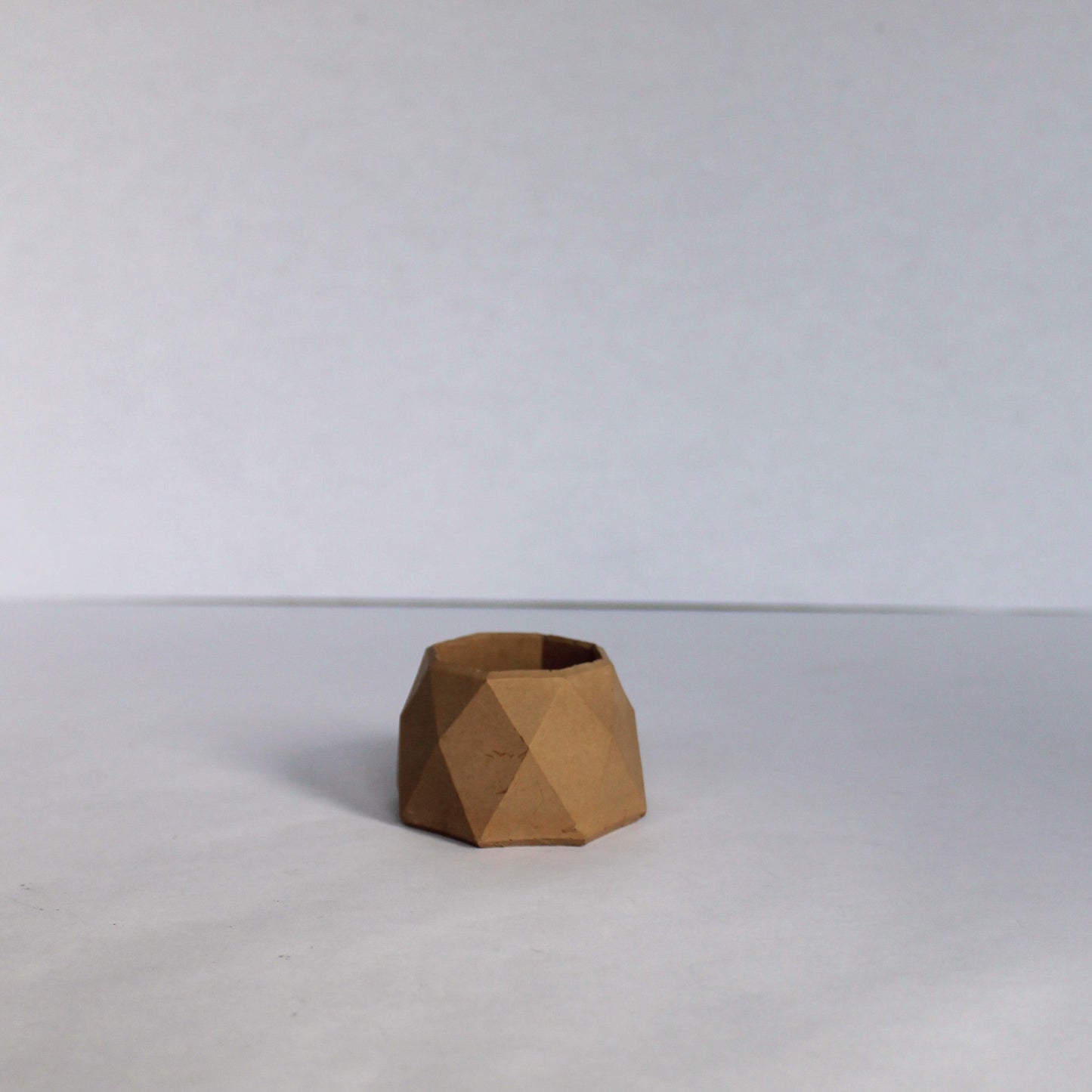 Beige geometric vase on a white background