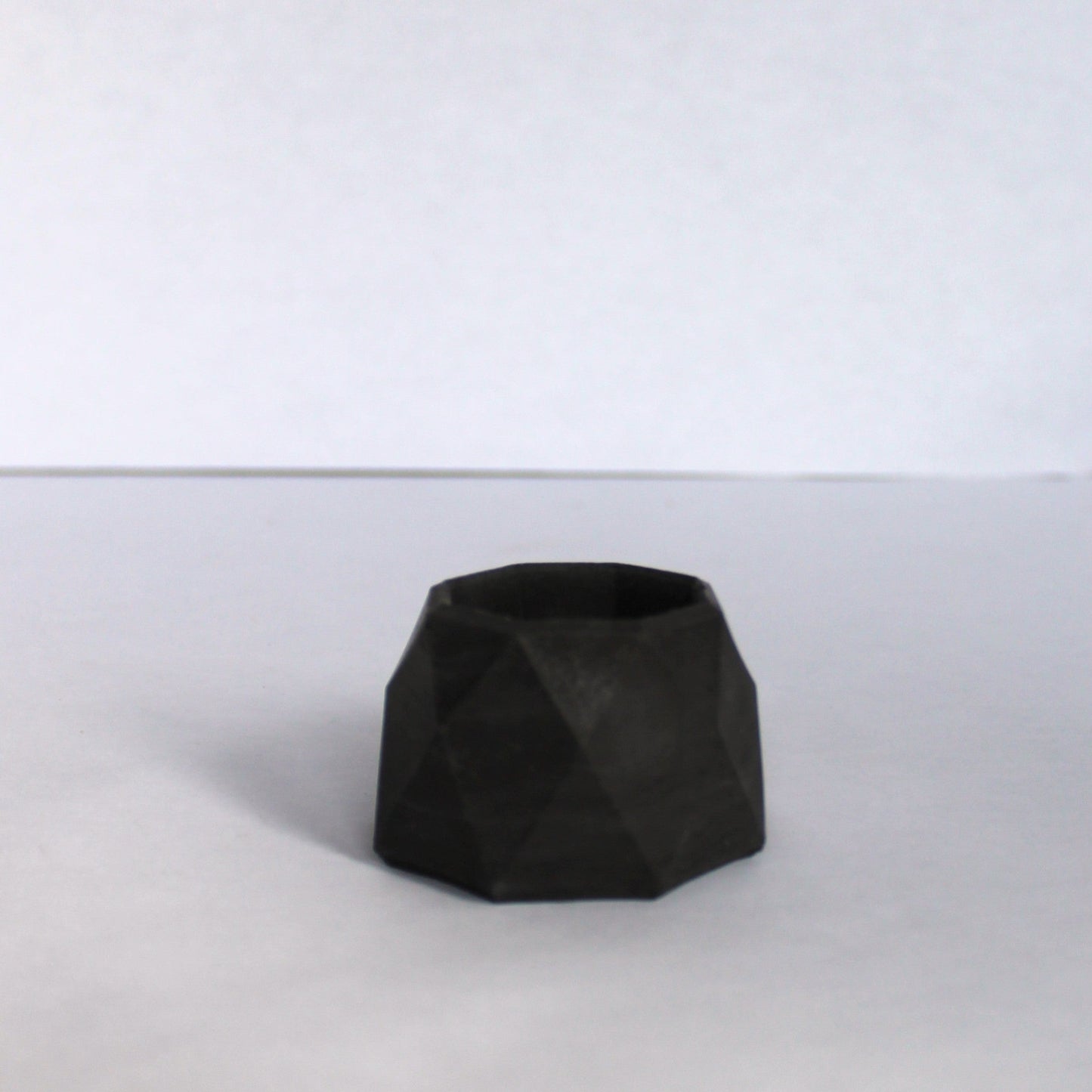 Black geometric concrete dish on a white background