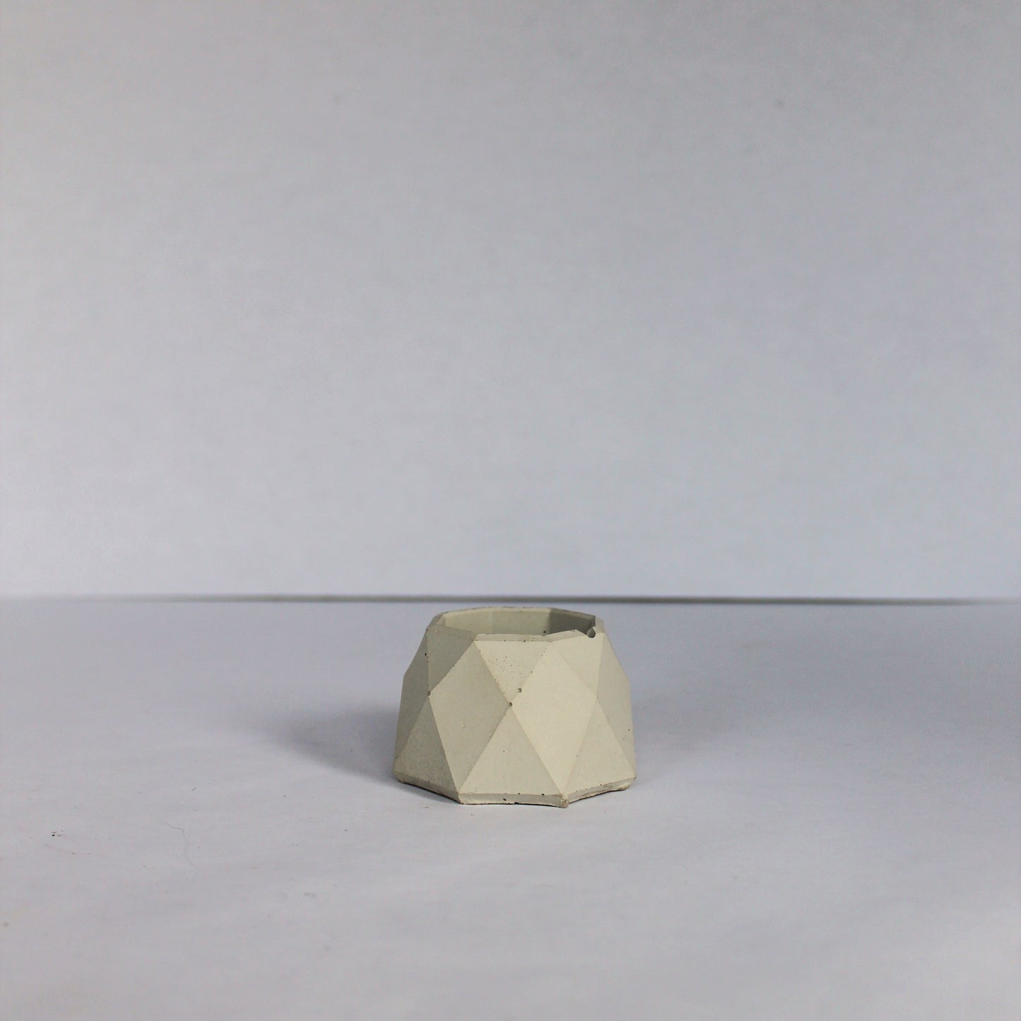 Light gray geometric concrete dish on a plain background