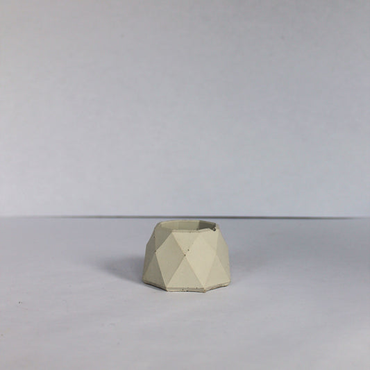 Light gray geometric concrete dish on a plain background