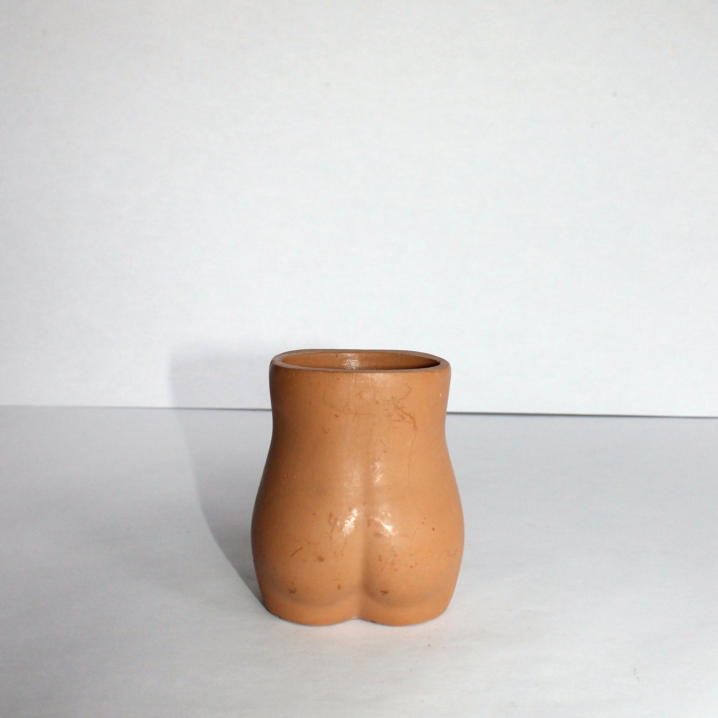 Concrete vase shaped like a female torso on a white background
