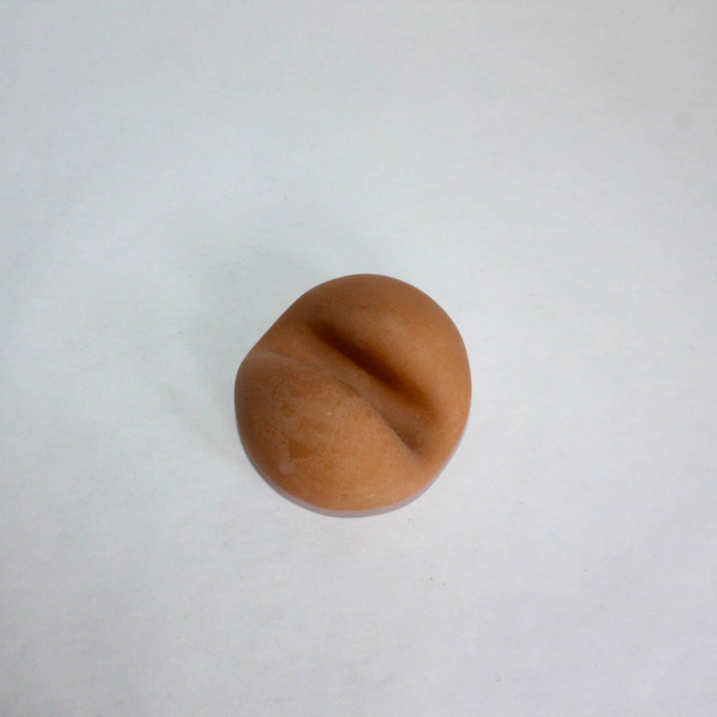 Terracotta circular phone holder on a white background