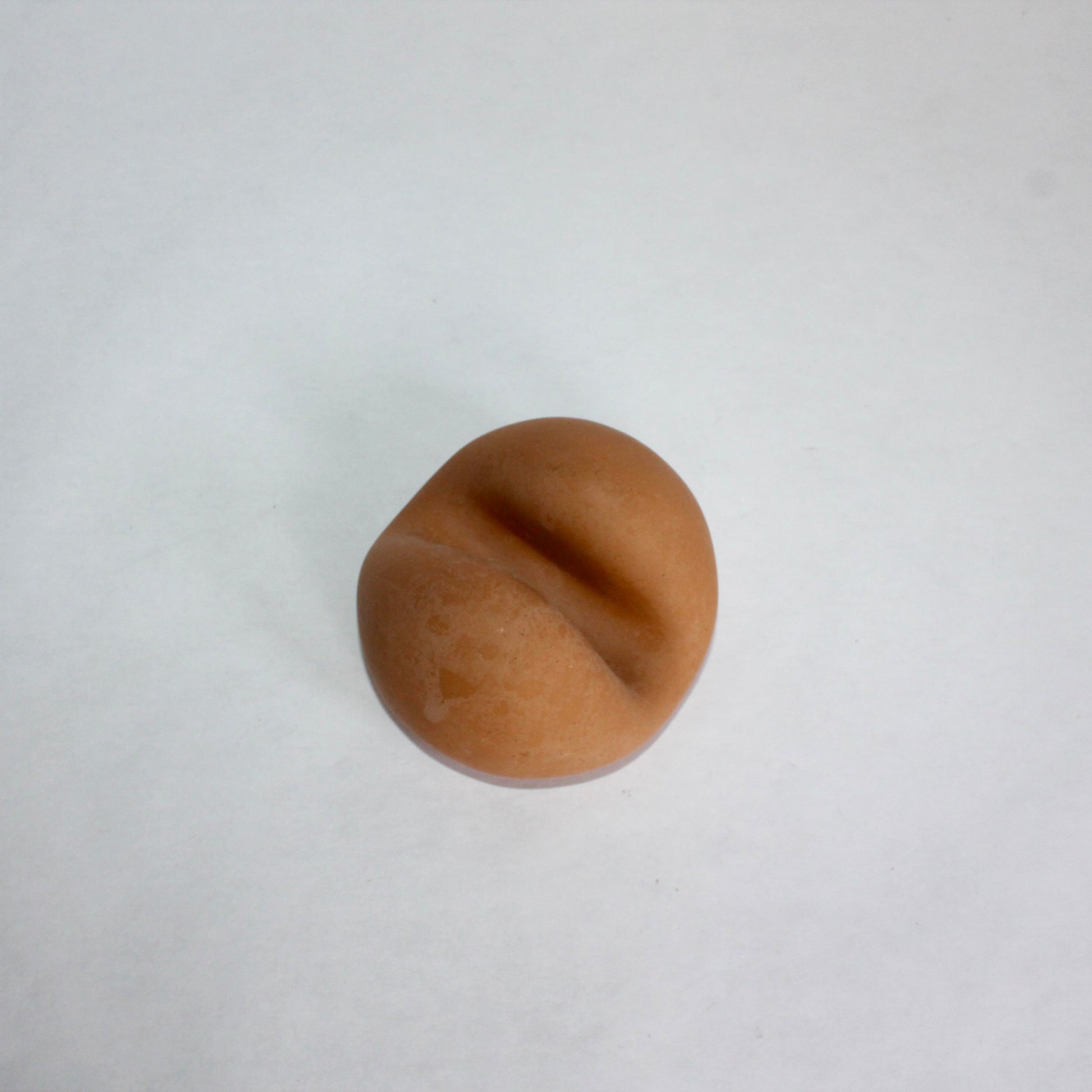 Terracotta circular phone holder on a white background