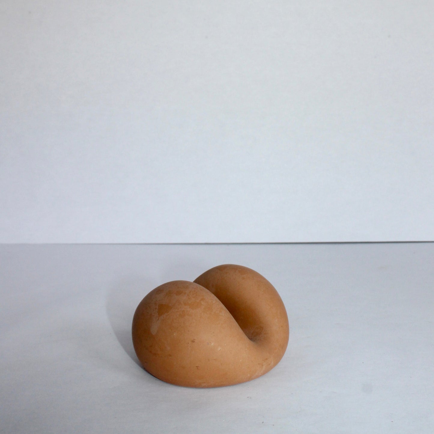 clay colored concrete phone holder on a white background