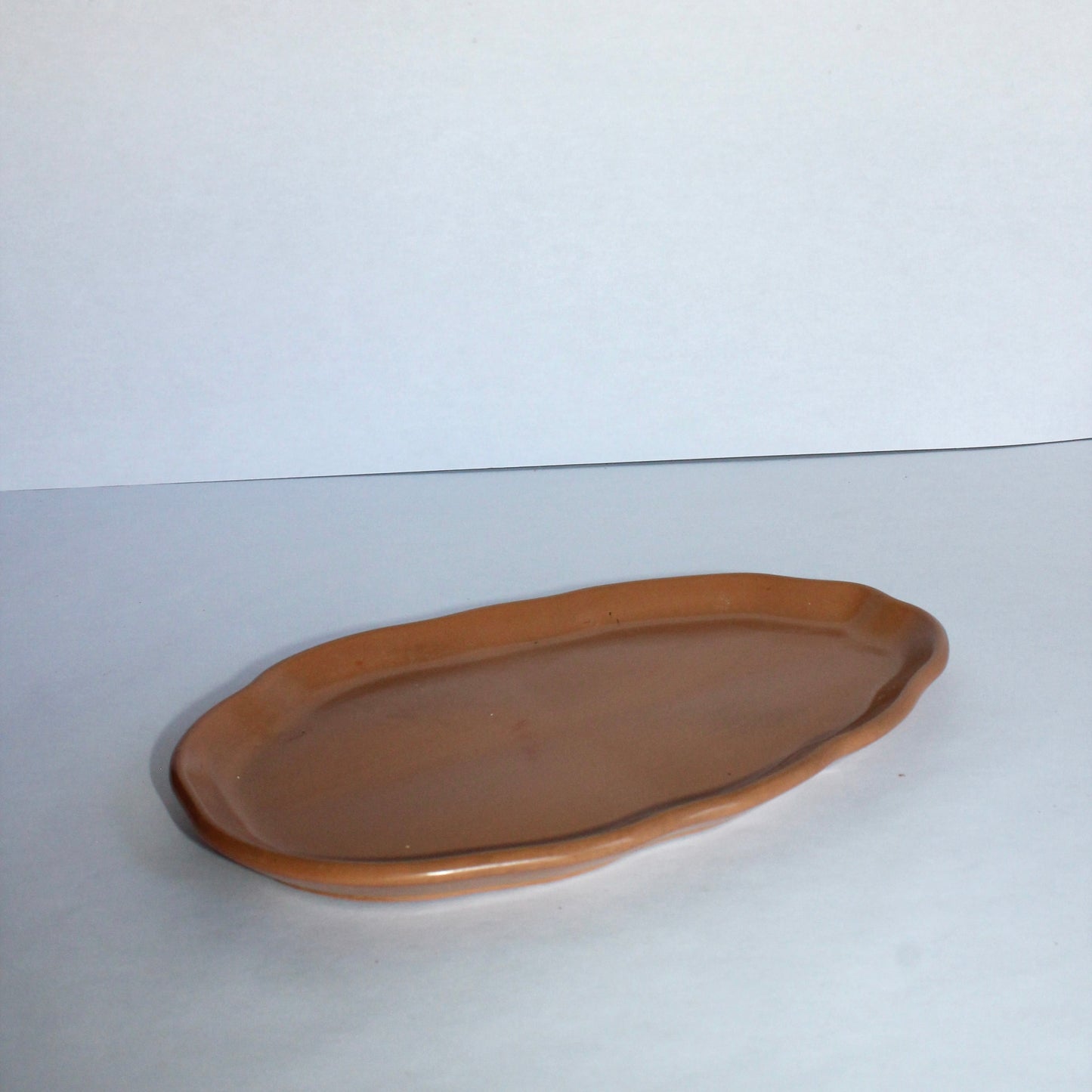 Side view of oval concrete tray on a white background